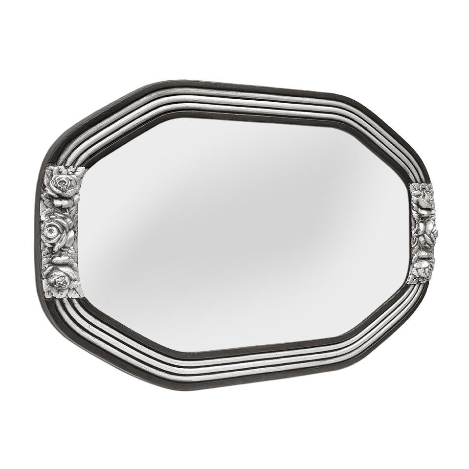 Miroir mural français ancien Art&Deco, patiné noir et argenté, de forme octogonale, vers 1920. Cadre antique original avec roses stylisées argentées. Dorure à la feuille. Largeur du cadre : 5 cm / 1.96 in. Miroir en verre moderne. Dos en bois.