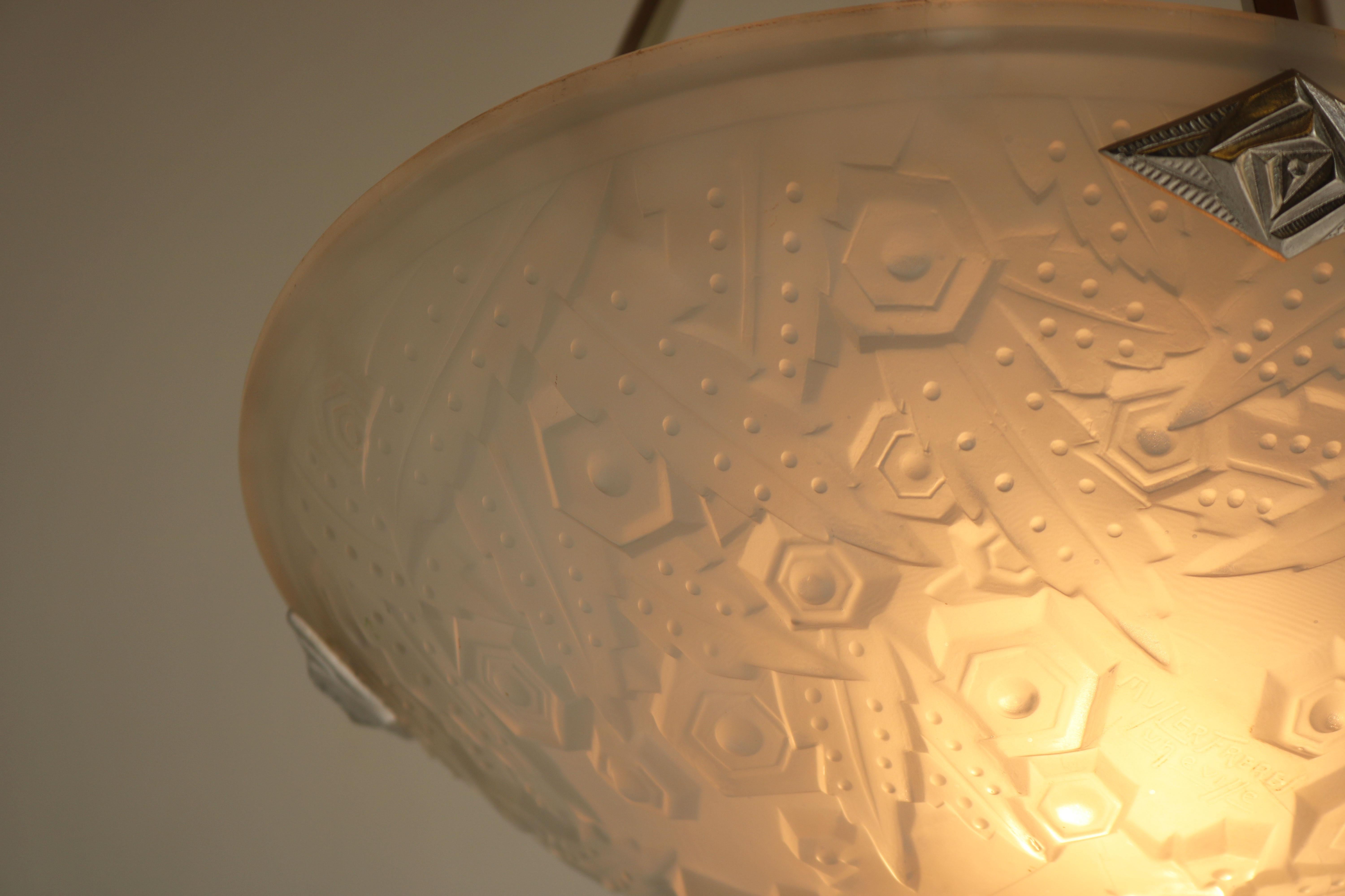 Wunderschön und zeitlos! Diese französische Art-Déco-Hängeleuchte von Muller Frères Luneville 1930.
Wunderschöner weißer Milchglasschirm mit erstaunlichen geometrischen Art-Déco-Motiven. 
Exquisiter Rahmen in Silber mit Art-Déco-Verzierungen.