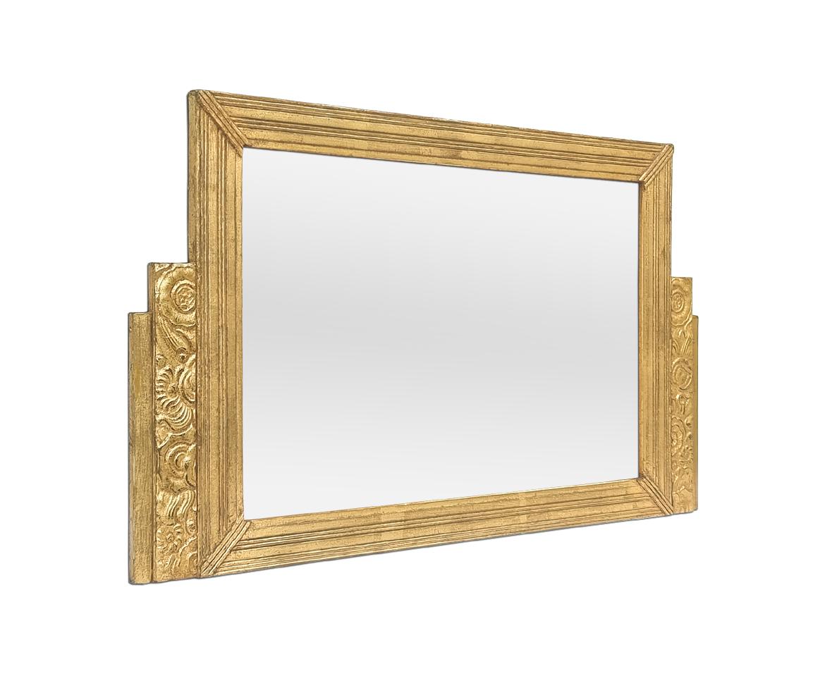 Antique French Art Deco period patinated giltwood mirror, circa 1925. Decorated with Art Deco-style floral motifs. Antique frame re-gilding with leaf. Frame width: 4 - 9 cm / 1.57 - 3.54 in. Modern glass mirror. Wood back.