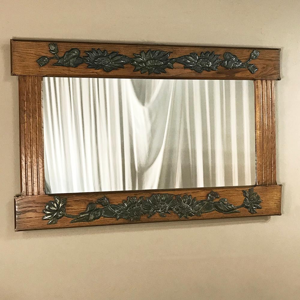Antique French Art Deco Period mirror features original pewter castings of elegant floral motives mounted atop solid white oak frame. The prior Arts & Crafts movement is clearly evident in the design of the framework, while the ornamentation