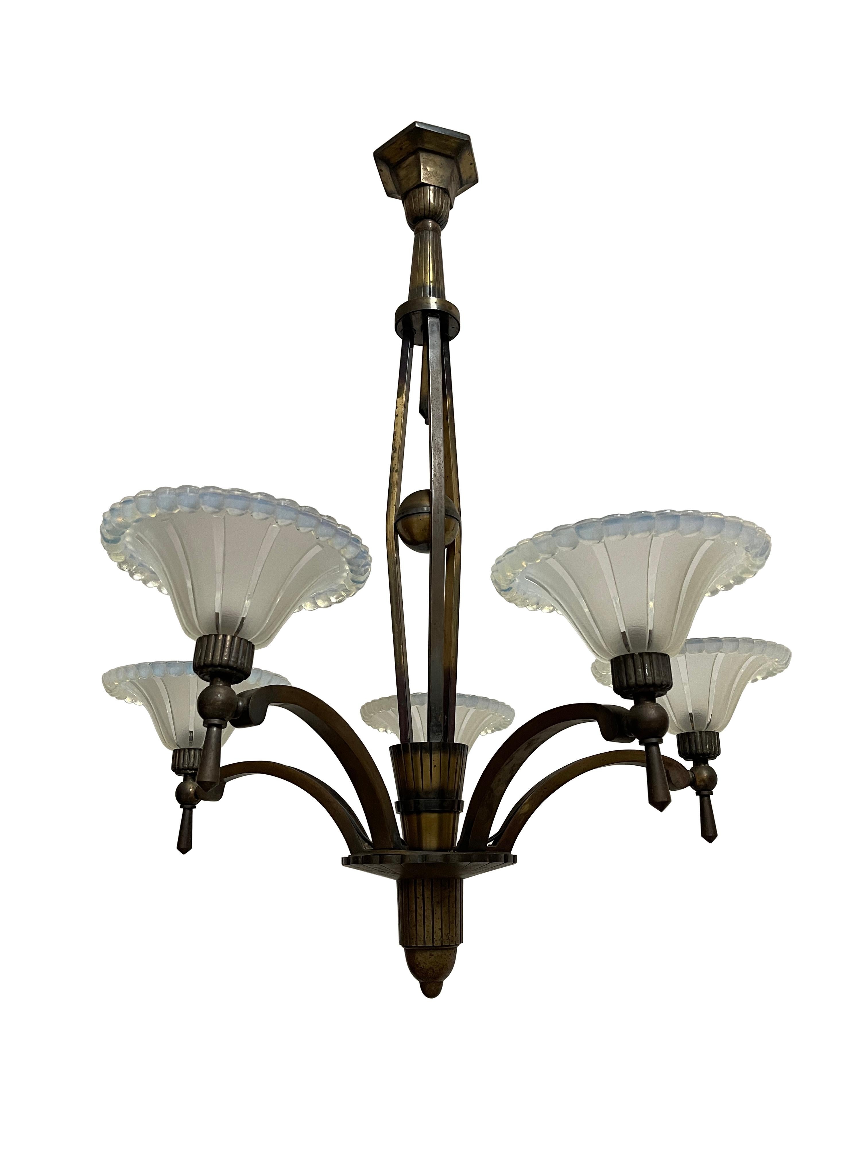 - A large French Art Deco gilded bronze five-arm ceiling chandelier featuring high-quality glasswork typical of Ezan, French circa 1930.
- The fixture comprises of five arched decorative arms each with reeded sconces encompassing Ezan frosted and
