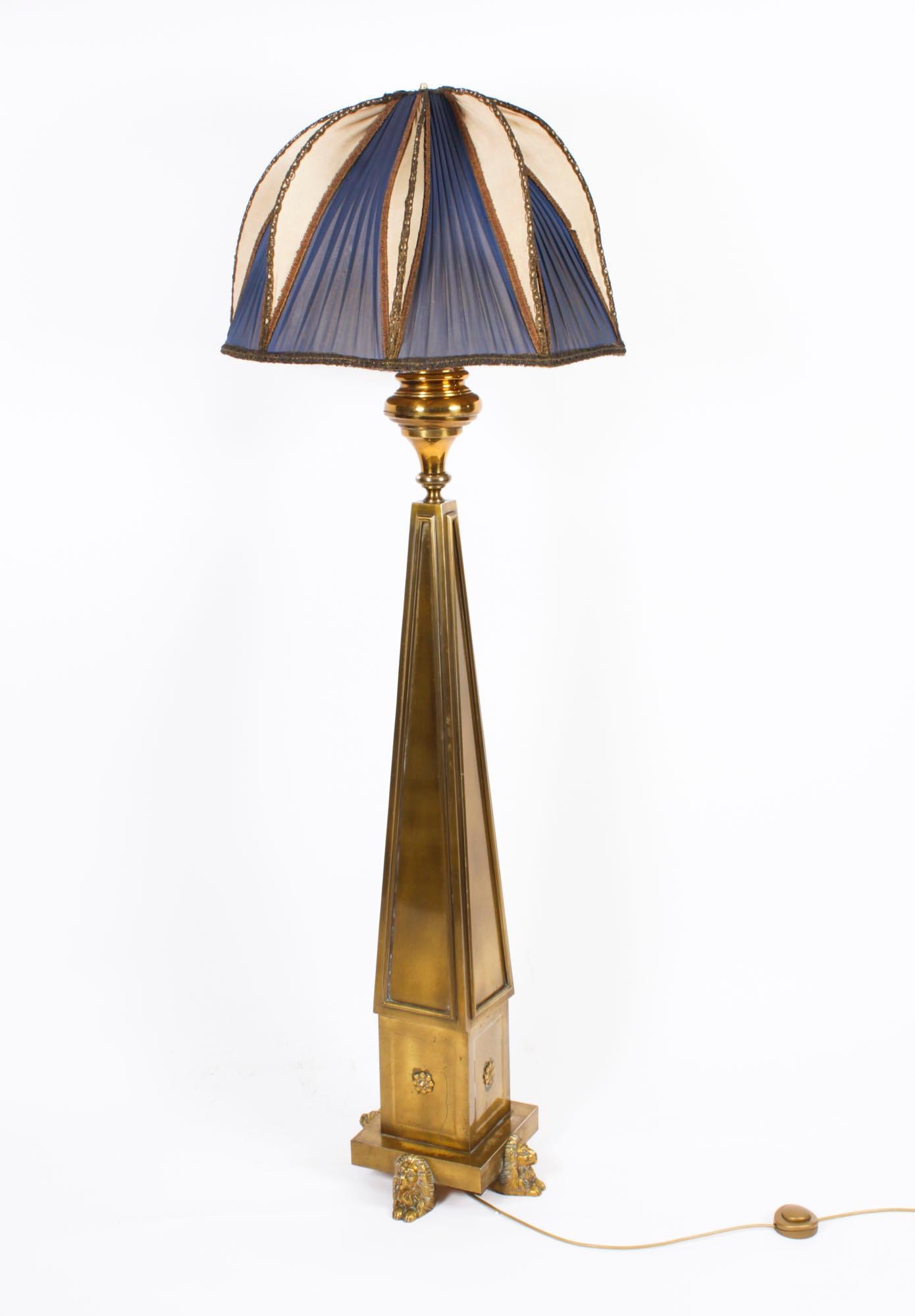 This is a highly attractive and exhibition quality antique French Art Deco brass and ormolu standard lamp and shade,  Circa 1920 in date.

This splendid lamp features a distinguished column with four triangular tapered sides rising from a stepped