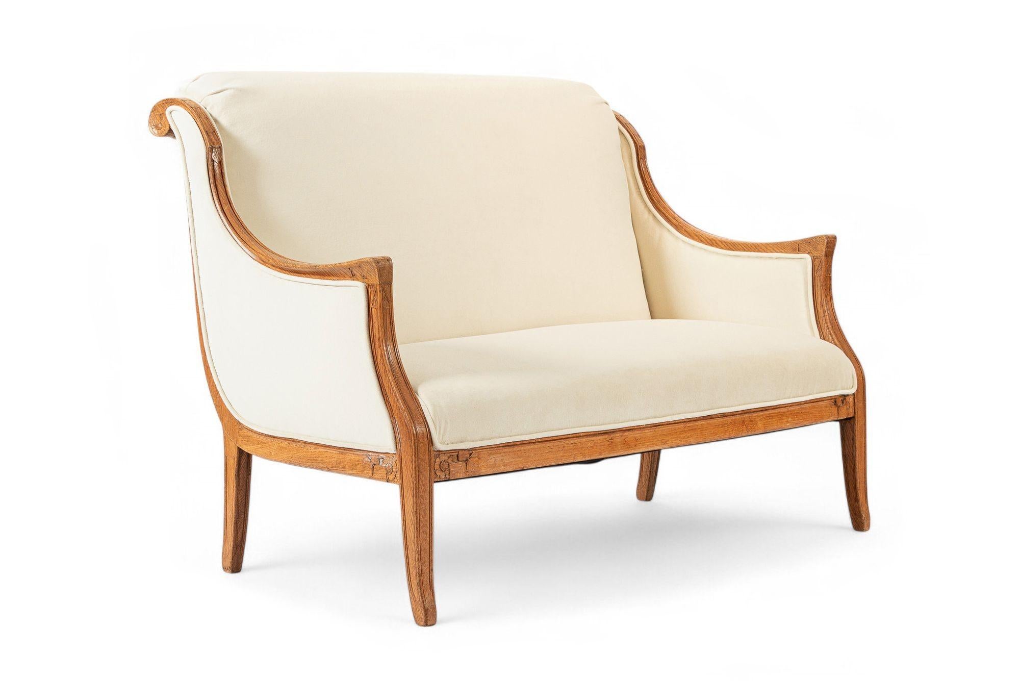 Dieses schöne antike französische Art-Deco-Liegesofa stammt aus den 1940er Jahren. Dieses gut gebaute, elegant proportionierte Zweisitzer-Liegesofa hat ein markantes Profil mit einem geschnitzten Massivholzrahmen und einer hohen, rollenden