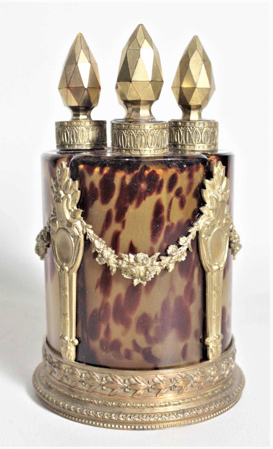 This antique set of four stoppered scent or perfume bottles was made in France in circa 1880 in the period Victorian style by an unknown maker. The uniquely shaped three sided bottles are done in mottled art glass using a deep red within a yellowish