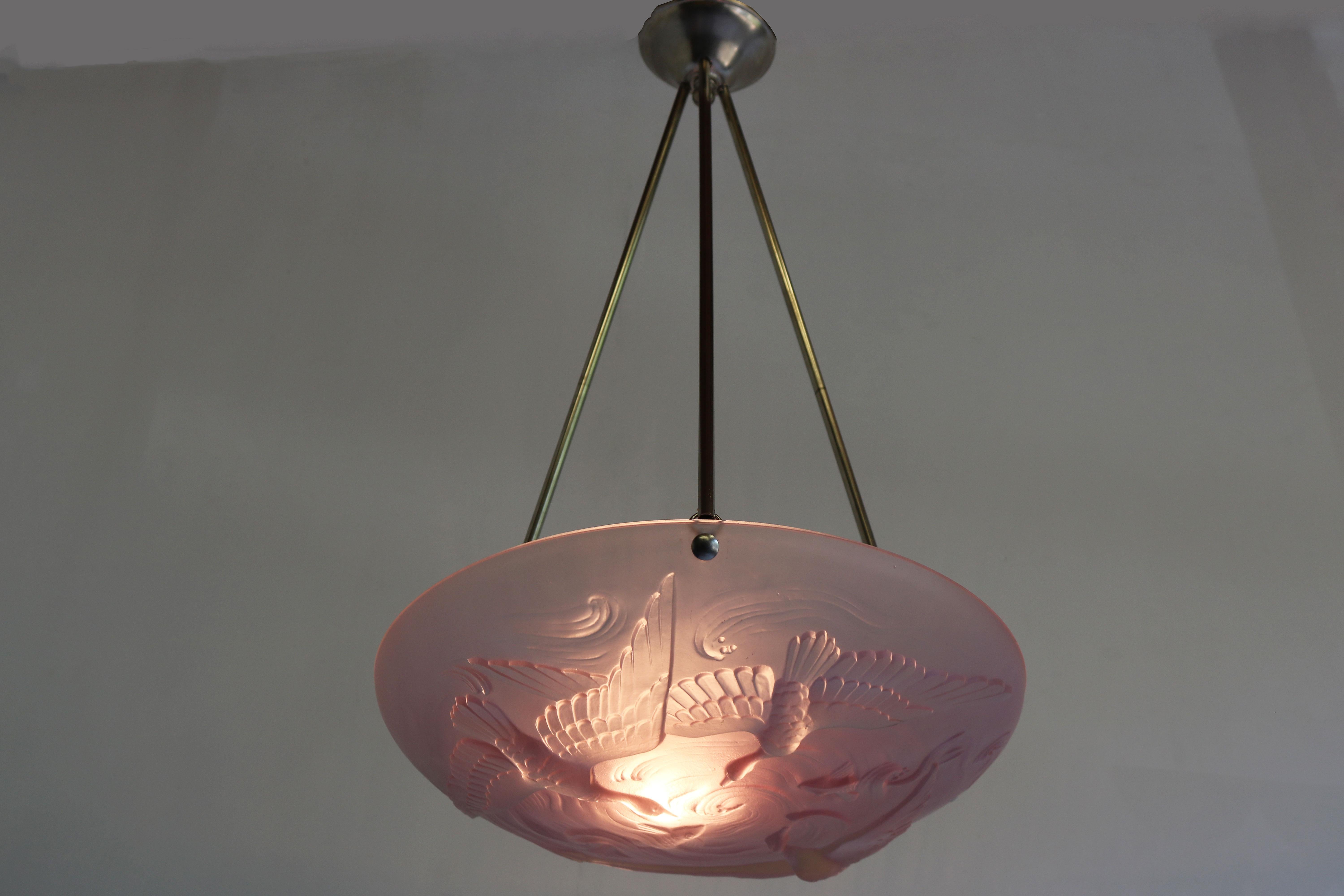 Exquisite French Art Deco / Art Nouveau pendant light by Verlys France with a pink/purple art glass shade displaying birds & fish. 
The glass is very thick with hand carved details. The scene looks amazing when lit and really comes to life. 
The