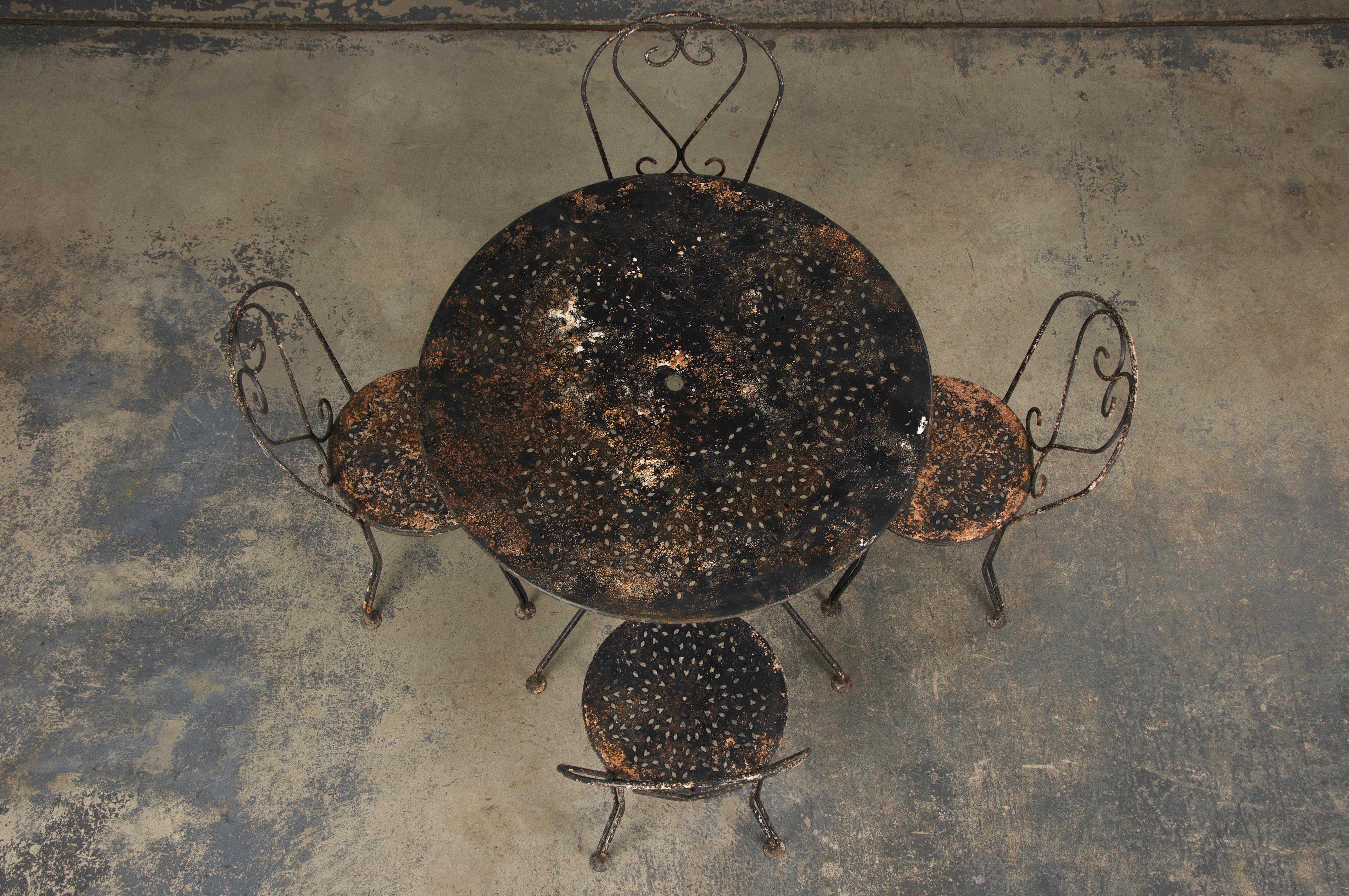 Un charmant ensemble de jardin noir Art nouveau français du début des années 1900, provenant directement de Provence, France. Cet ensemble comprend une table ronde et quatre chaises d'appoint, toutes méticuleusement fabriquées à la main en fer