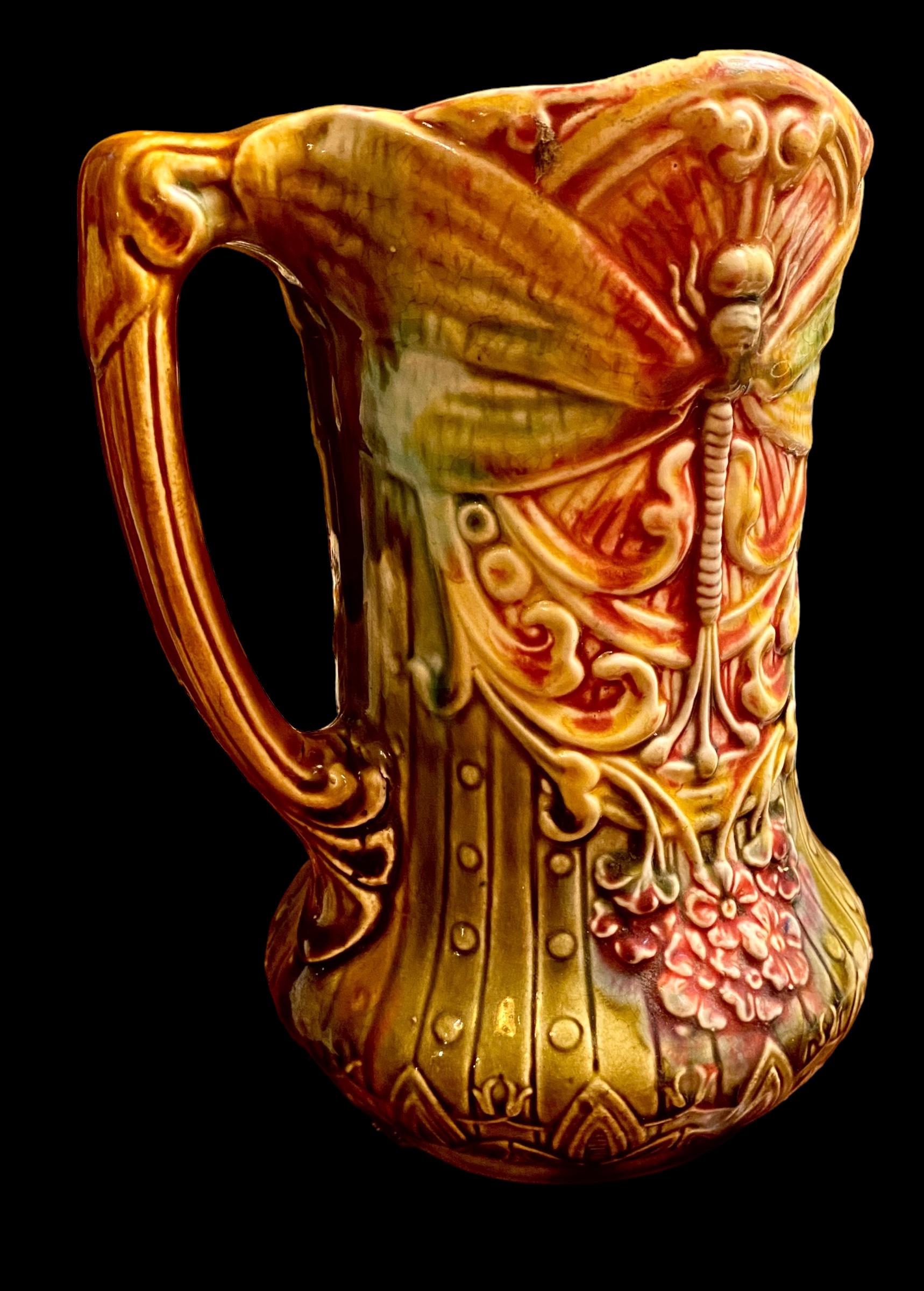 A beautiful example of fine majolica from the Art Nouveau period in France in the coveted dragonfly pattern. The Colors are stunning in shades of red, gold, olive green, mint green and yellow. 
La Faiencerie d'Onnaing produced majolica from
