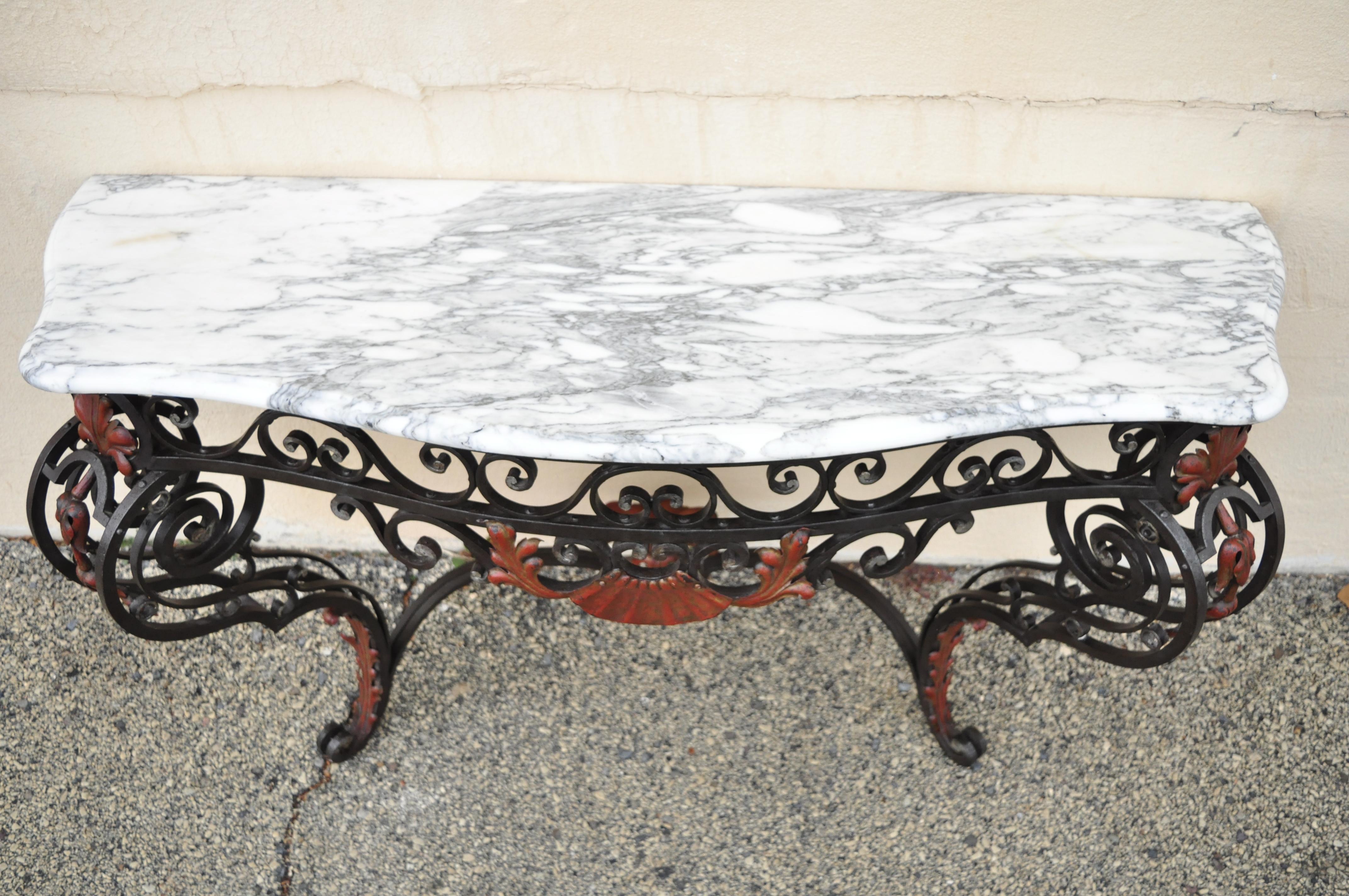 Ancienne table de salle console murale en fer forgé à plateau de marbre. Cet objet se compose d'une console murale, d'un plateau en marbre façonné et d'une base en fer forgé décorée de coquillages et de fleurs. Il s'agit d'un très bel objet ancien,