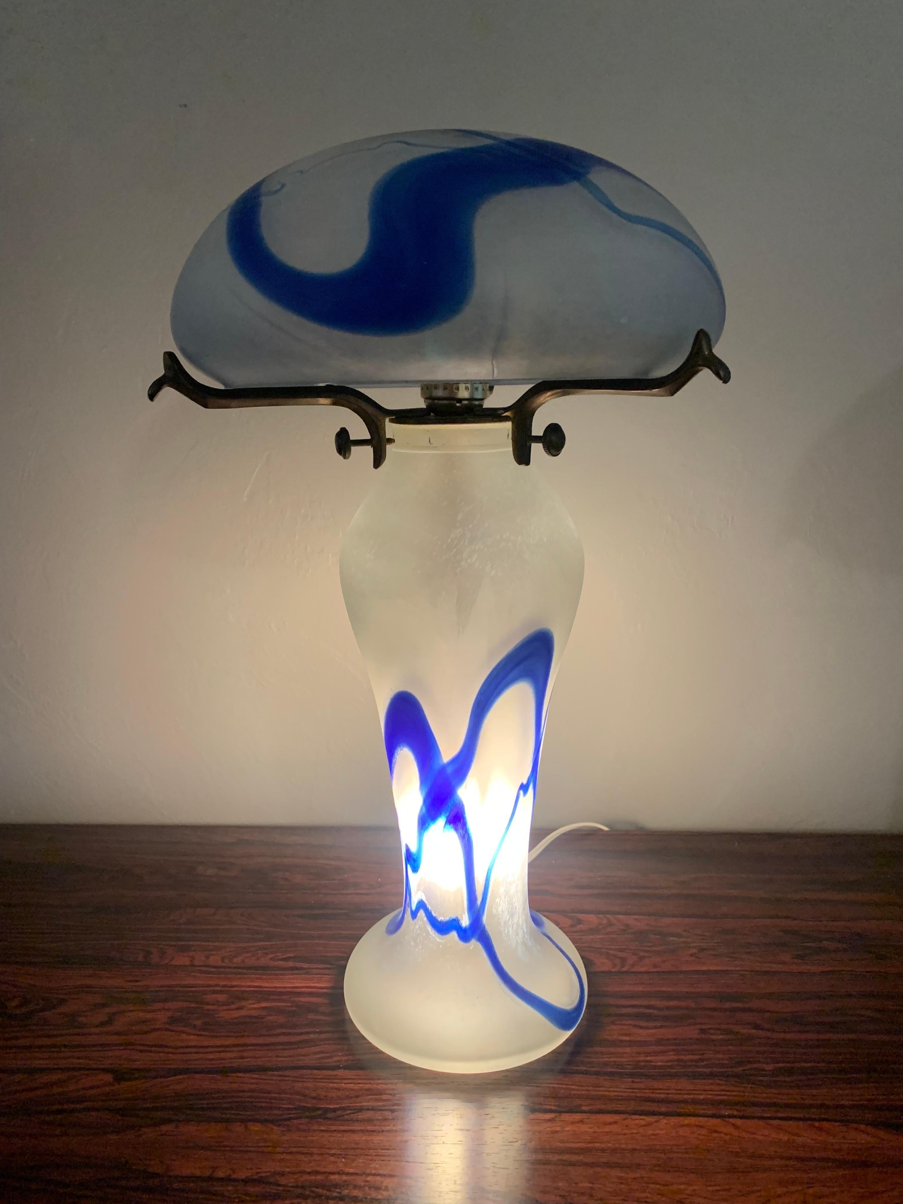 Exquisite Art Nouveau lamp made in France. 

Traditional mushroom shape with a rounded dome. Glass base and the two pieces all come together with a brass stem that attaches to the base. 

Blue, white and clear glass. 

Circa 1900s. 

There is a