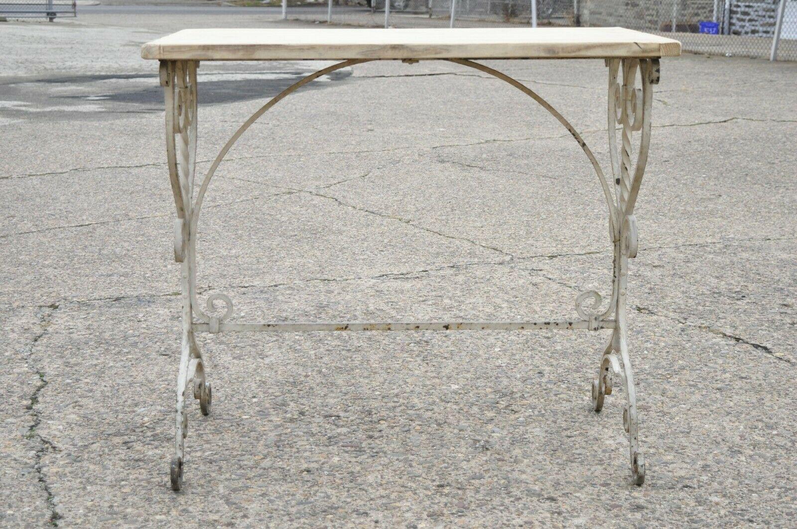 Ancienne table de travail en fer forgé à volutes, de style Art Nouveau, avec plateau en bois de 42 pouces. Cet objet présente une base datant du début des années 1900, le plateau semble avoir été ajouté plus récemment ou utilisé à d'autres fins, une