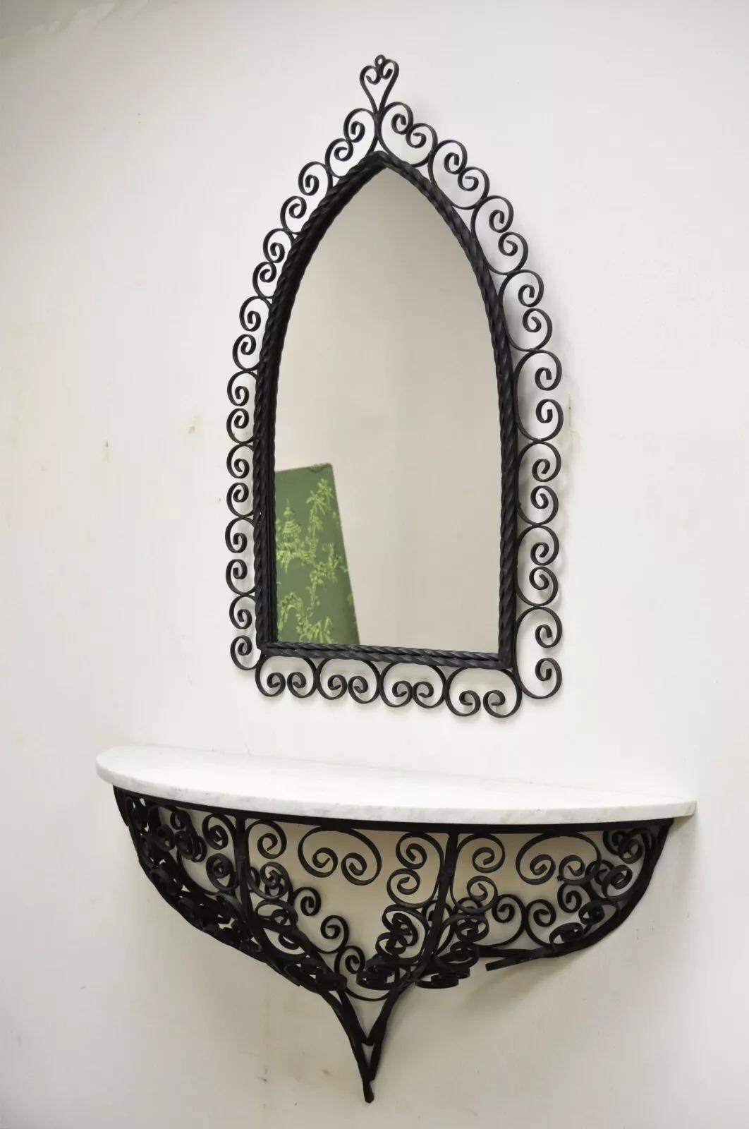 Antique French Art Nouveau Scrolling Wrought Iron Wall Mounted Console Table and Mirror. Listing includes a marble top wall hanging console table and arched scrolling mirror. Circa Early 20th Century. Measurements: Mirror: 36