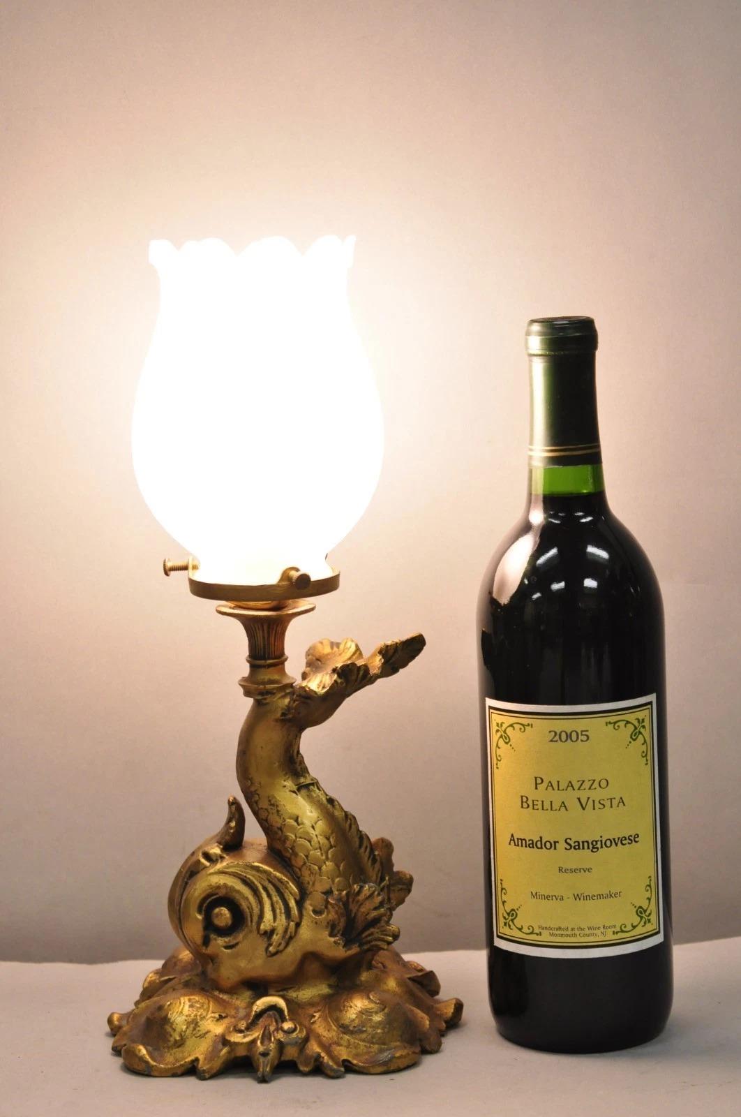 Petite lampe de chevet en métal doré avec dauphin figuratif et abat-jour tulipe en verre dépoli. Circa Early 20th Century. Dimensions : 12,5