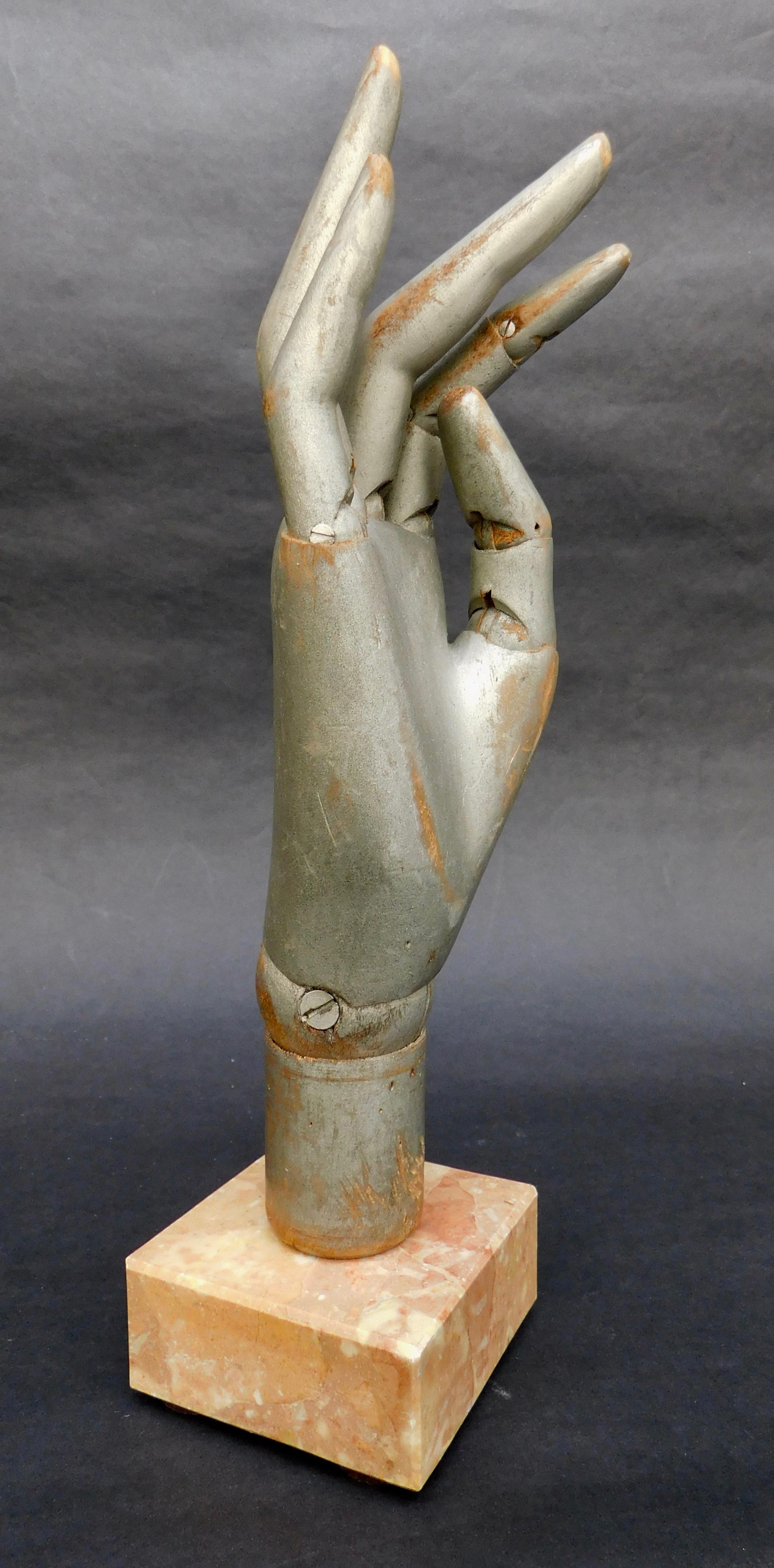 A lifesize mannequin hand with fully articulated fingers and wrist. Moveable to create endless positions. Mounted on an Italian marble stand with a wooded peg so that the hand can be easily removed if so desired.