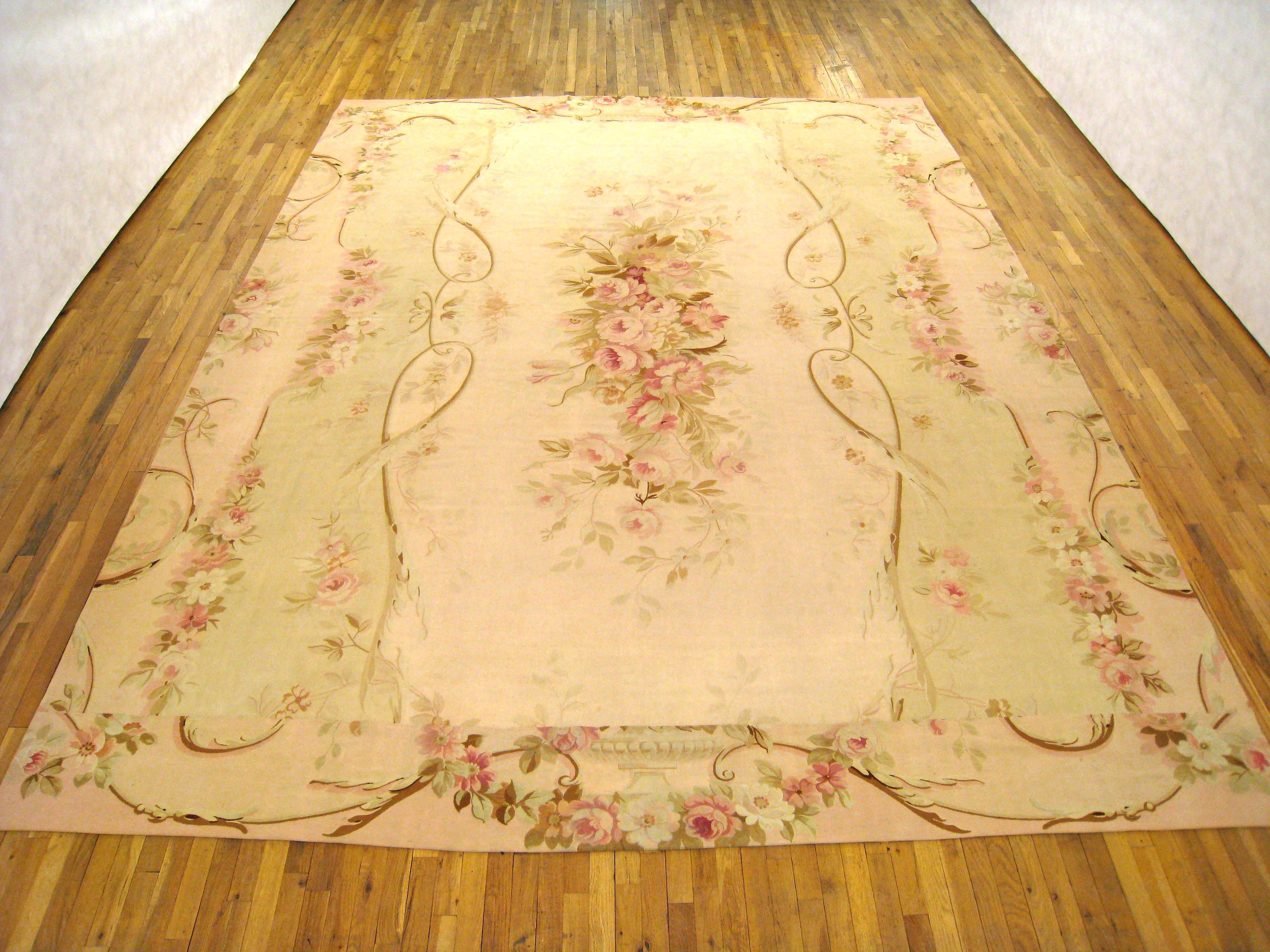 An antique French Aubusson carpet, size 14'0 x 10'9, circa 1890. This fine Louis Philippe era flat-woven French wool carpet features an elegant floral medallion at center, and a unique arrangement of outer borders, which reciprocate the colors and