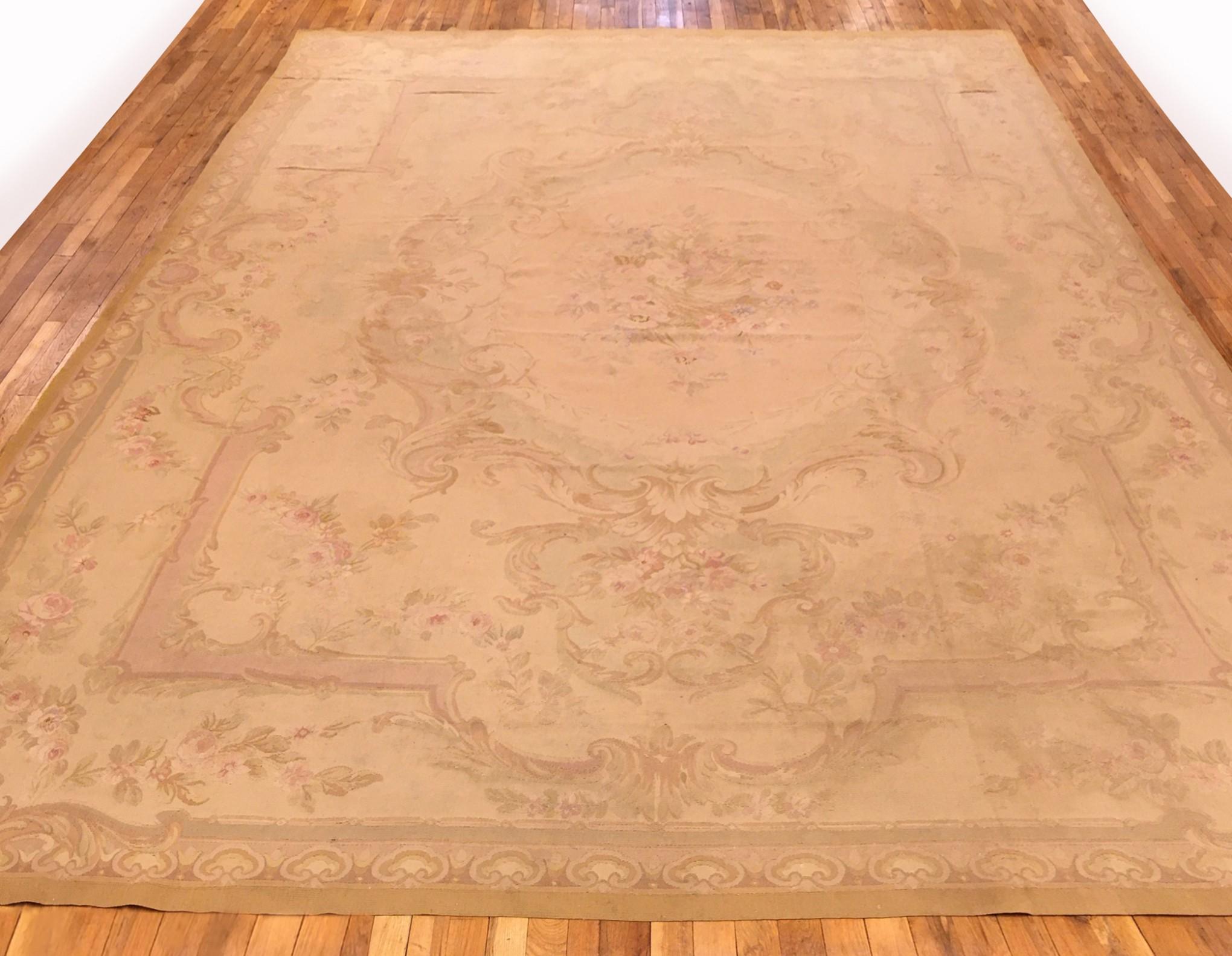 Un ancien tapis français d'Aubusson, de dimensions 14'0 x 9'10, vers 1890. Ce beau tapis en laine tissé à plat de l'époque Louis Philippe présente un élégant médaillon et une bordure extérieure délicatement travaillée, avec des couleurs ivoires