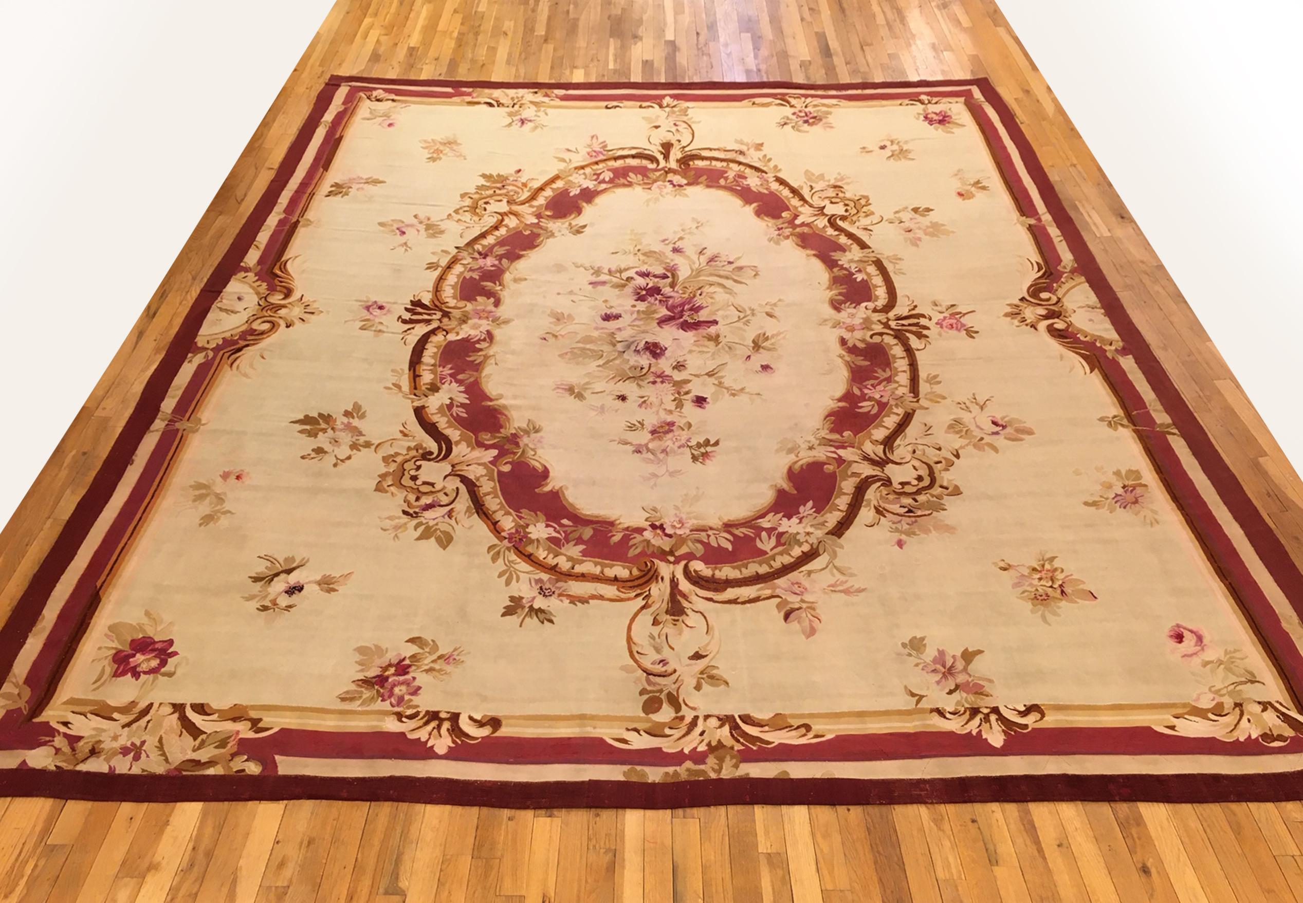An antique French Aubusson carpet, size: 13'4 x 10'8, circa 1890. This fine Louis Philippe era flat-woven French wool carpet features a large and dynamic central medallion on a relatively sparse ivory field, with a primary border which reciprocate