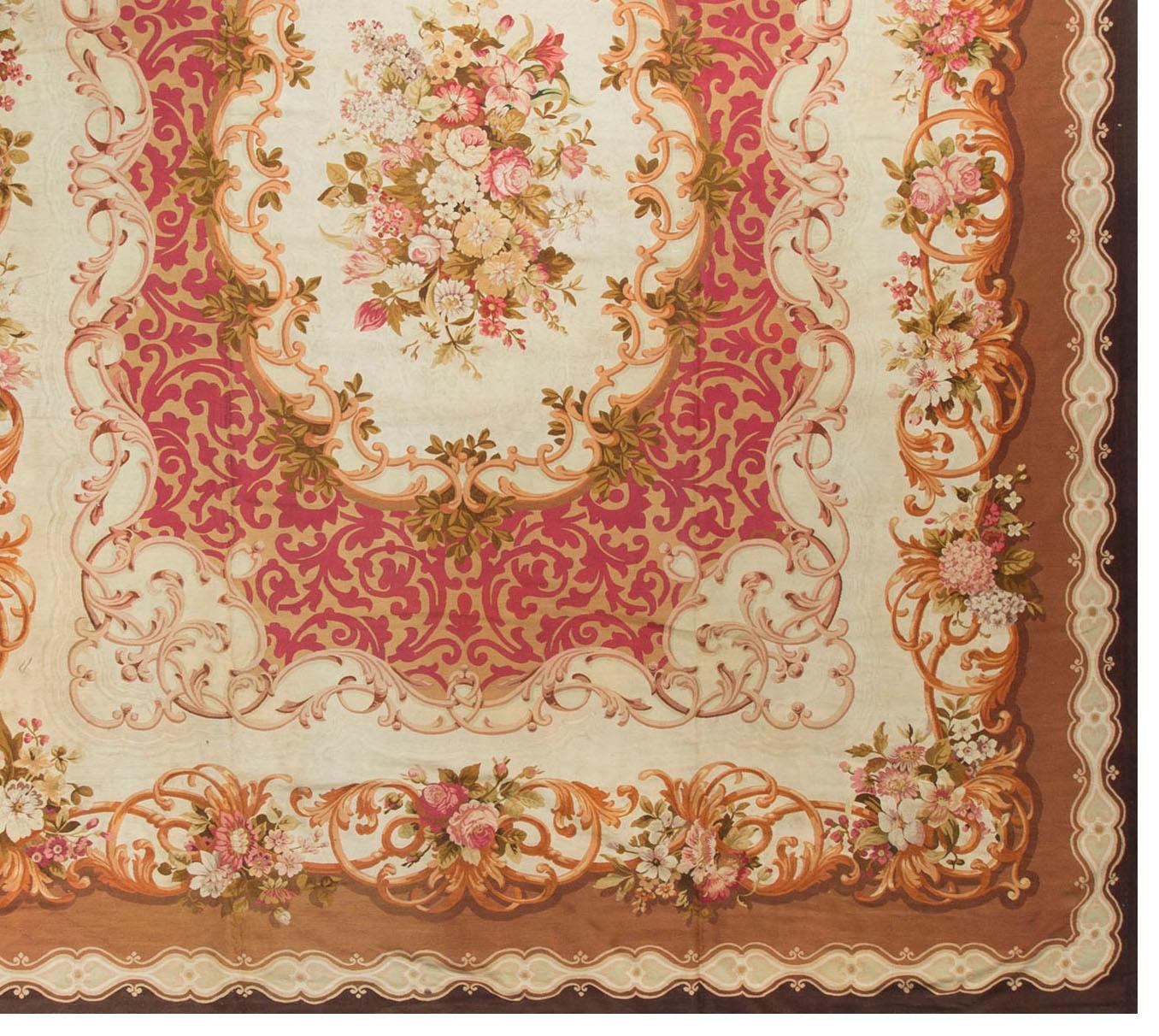 Antique French Aubusson rug carpet, circa 1890 13'4 x 16'6. Typical French Aubusson design, with the central ivory medallion surrounded by a rose colored swirl, full of gold leaf stems, this itself enclosed in an ivory field with a floral motif on