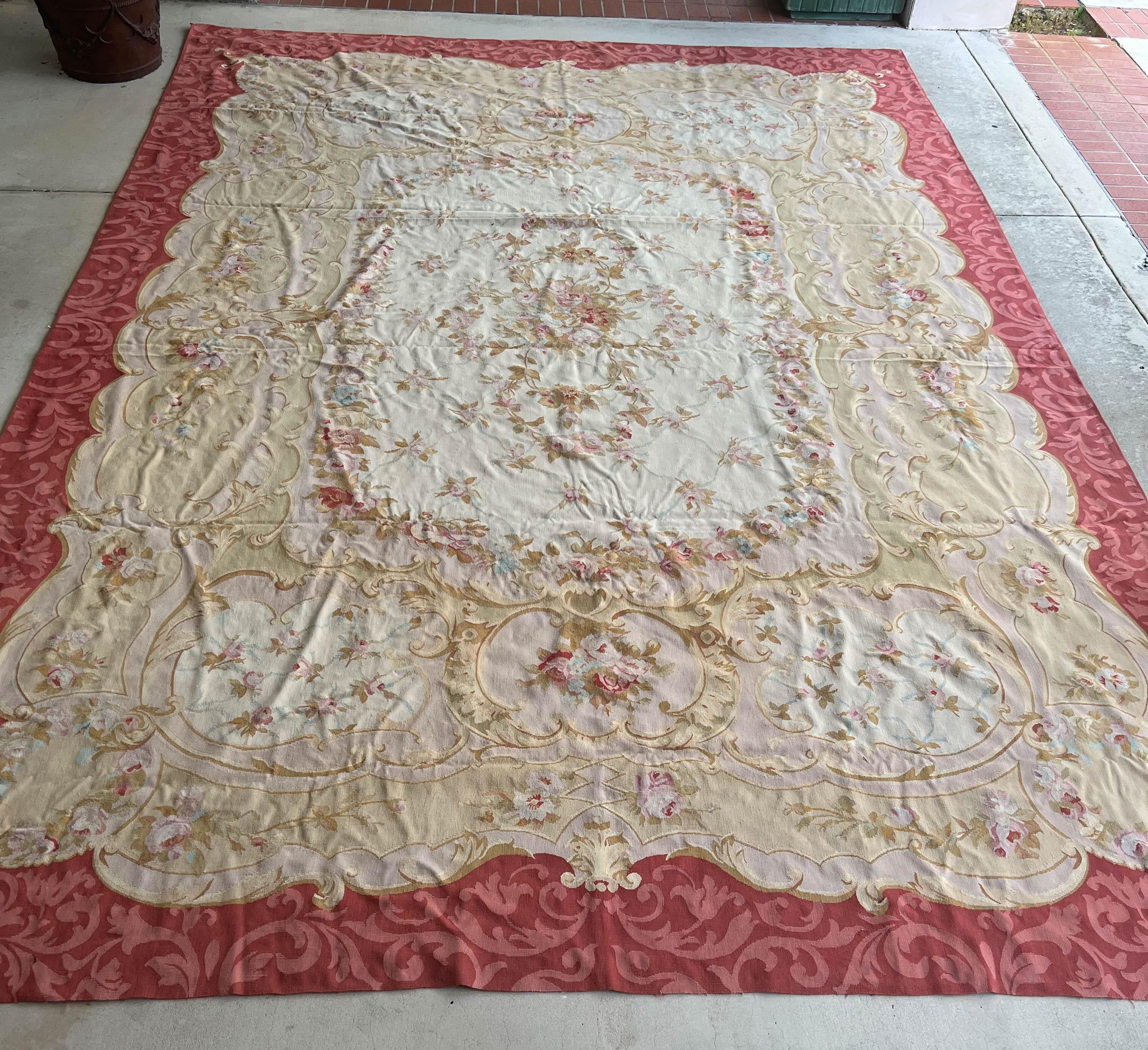 A classically designed Aubusson rug with designs of flowers, foliage, and scrolls surrounded by a pink border. Aubusson carpets are pileless and woven in the same way as tapestries.
Situated on the banks of the River Creuse in France, Aubusson had