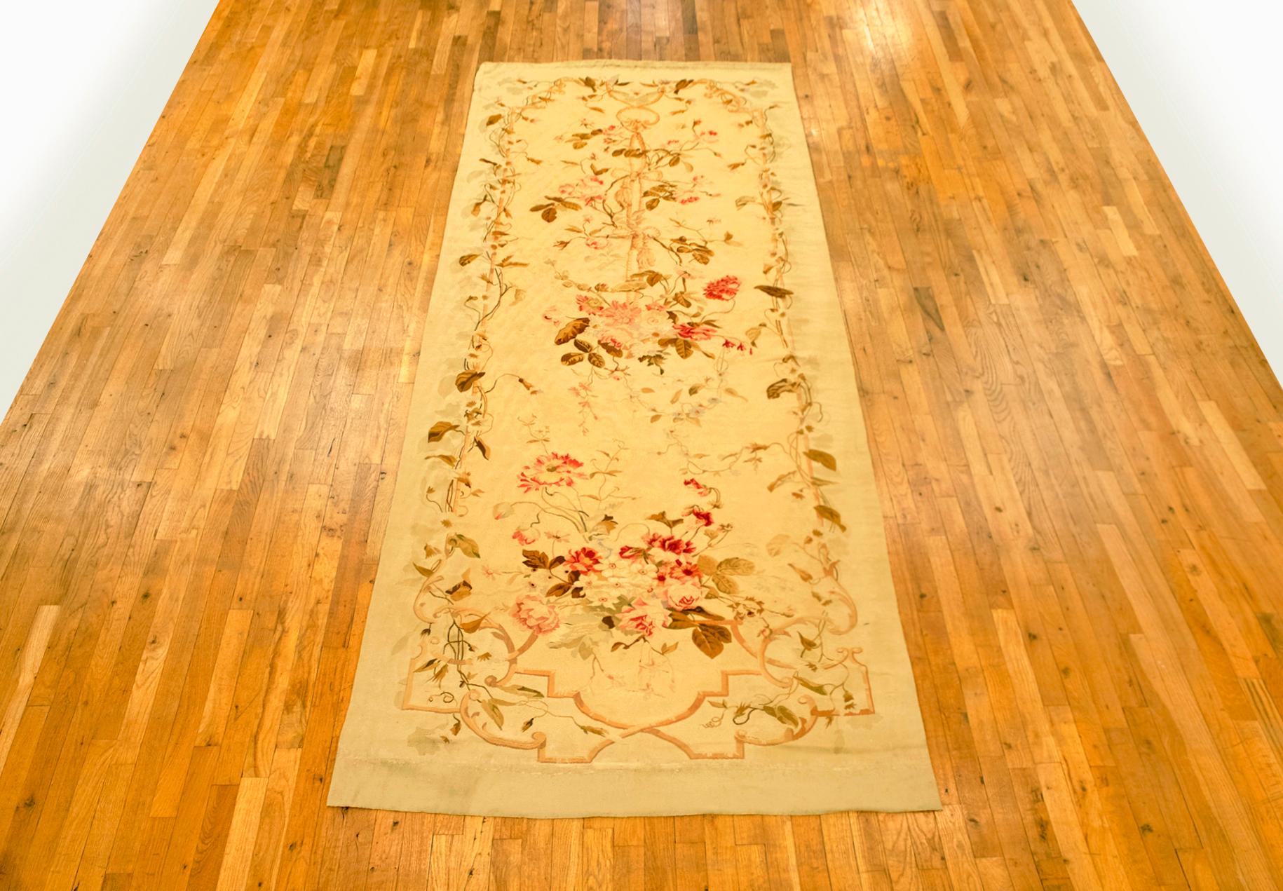 Antique French Aubusson rug, gallery size, circa 1890.

A one-of-a-kind antique French Aubusson Carpet, hand-knotted with soft wool pile. This lovely hand-knotted wool rug features floral elements in a directional design on the ivory primary field,