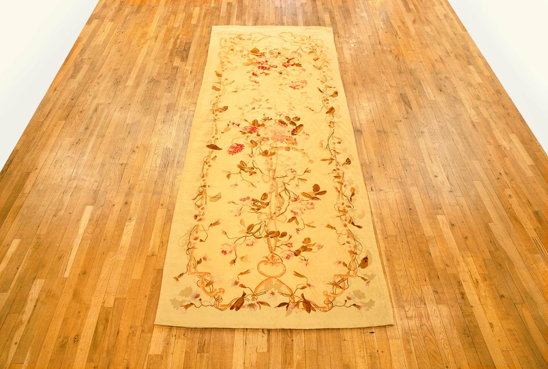 Antique French Aubusson rug, gallery size, circa 1890.

A one-of-a-kind antique French Aubusson Carpet, hand-knotted with soft wool pile. Featuring floral elements in a directional design on the ivory primary field, with a delicate rose outer