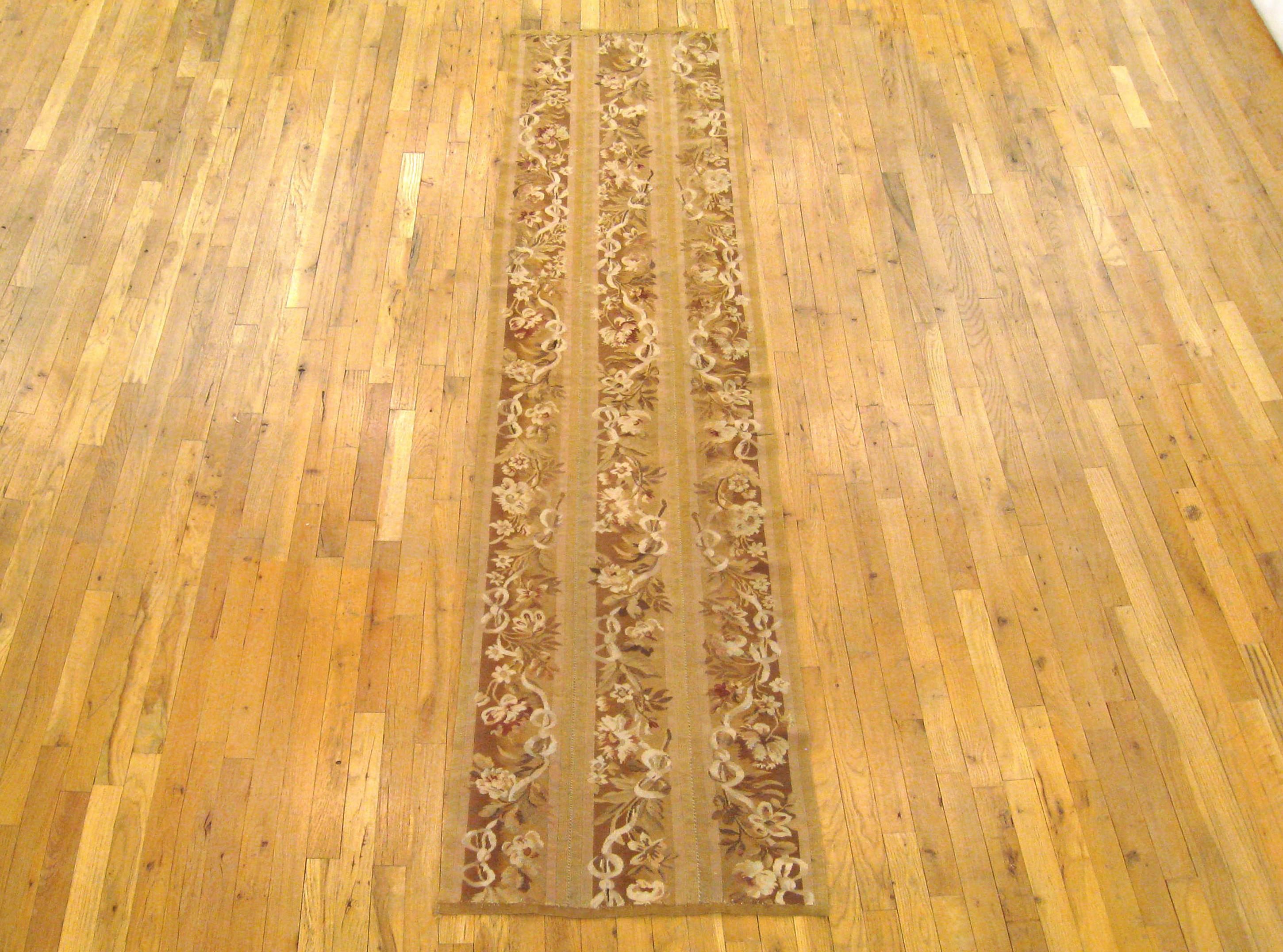 Antique French Aubusson Rug, Runner size, circa 1920

A one-of-a-kind antique French Aubusson Carpet, hand-knotted with soft wool pile. This lovely hand-knotted wool rug features floral elements allover the light brown primary field, with a delicate