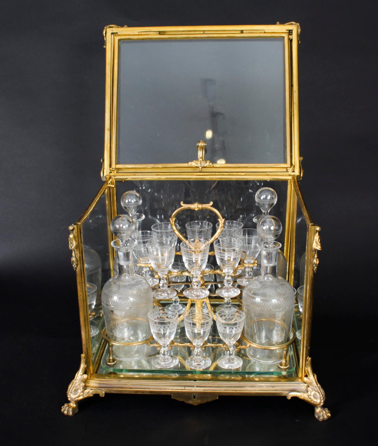 This is an exquisite antique French Napoleon III Bacarrat ormolu and glass Cave a Liqueur, or tantalus, circa 1860 in date. 

The Cave a Liqueur features an ormolu case with glass panels and an 'up and over' lid enclosing a gilt bronze frame