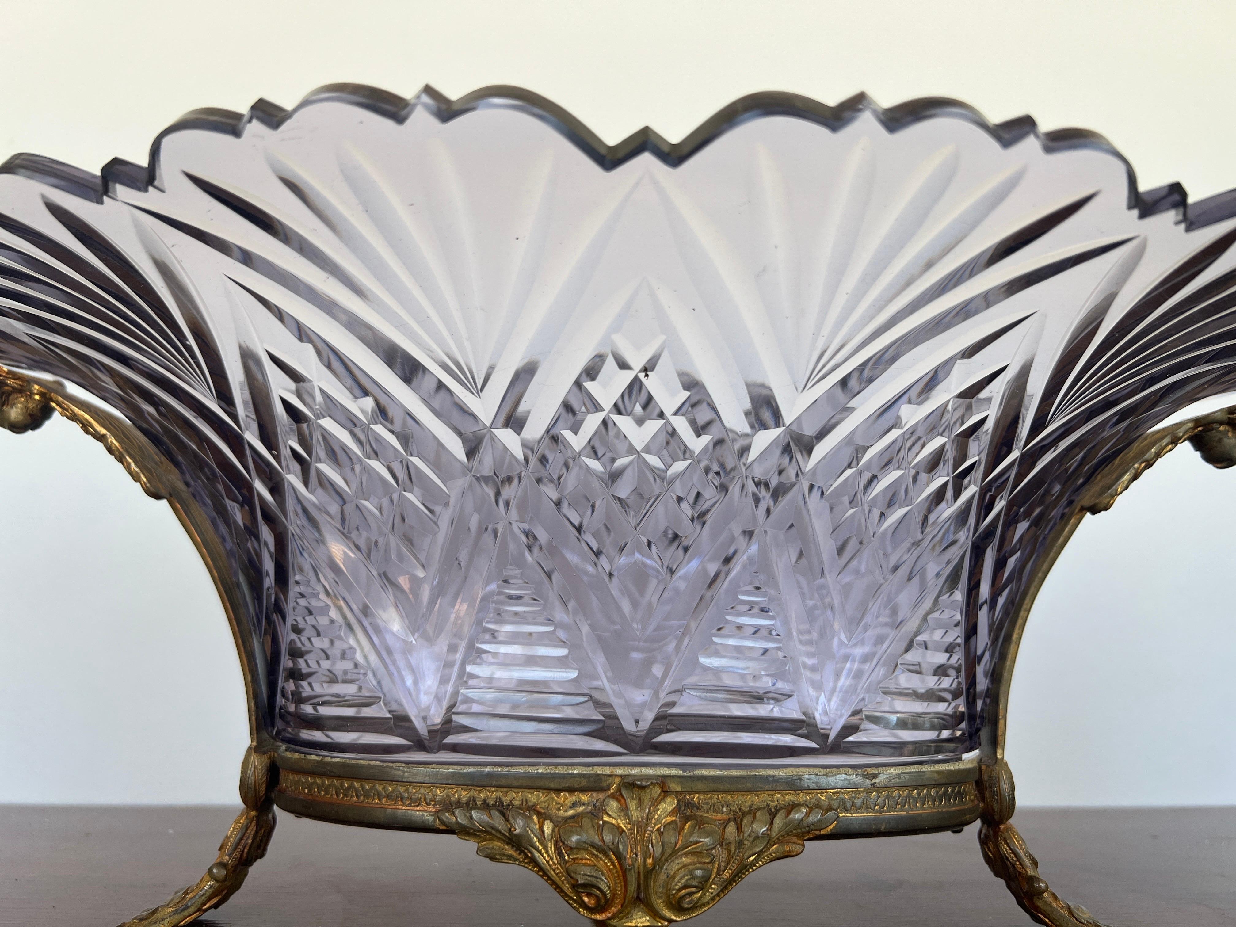 French, likely Baccarat late 19th century. A finely cut amethyst glass centerpiece bowl with ripped cut rim and diamond etched surround. The main body is set inside a bronze base with beautiful ram head supports, foliate rim and supported by four