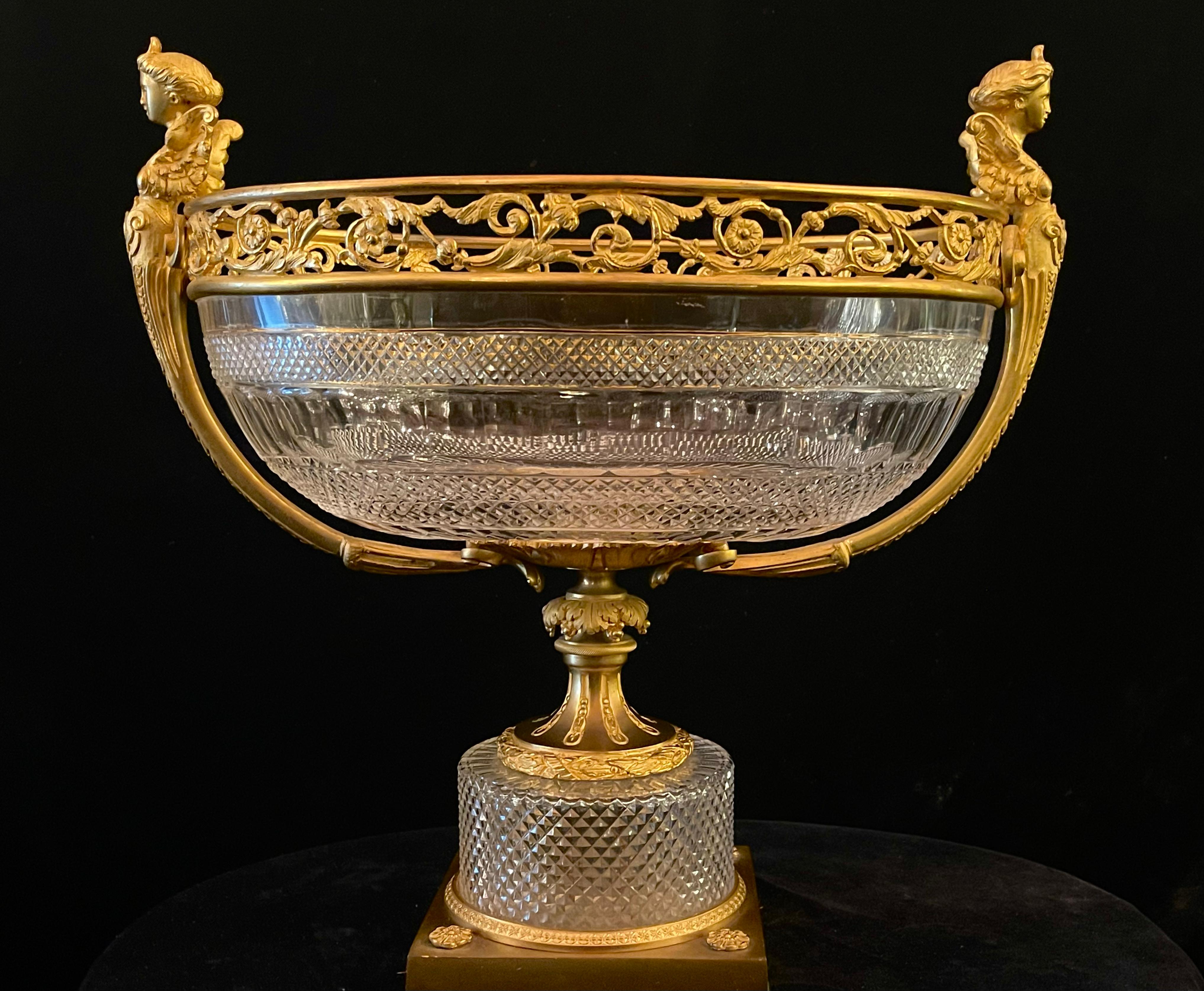 Un exquisito y finamente elaborado Gran Centro de Mesa Francés Baccarat Estilo Luis XVI de Bronce Dorado y Cristal Tallado. Este inusual centro de mesa presenta un llamativo cuenco ovalado de cristal con los lados graciosamente acampanados y un