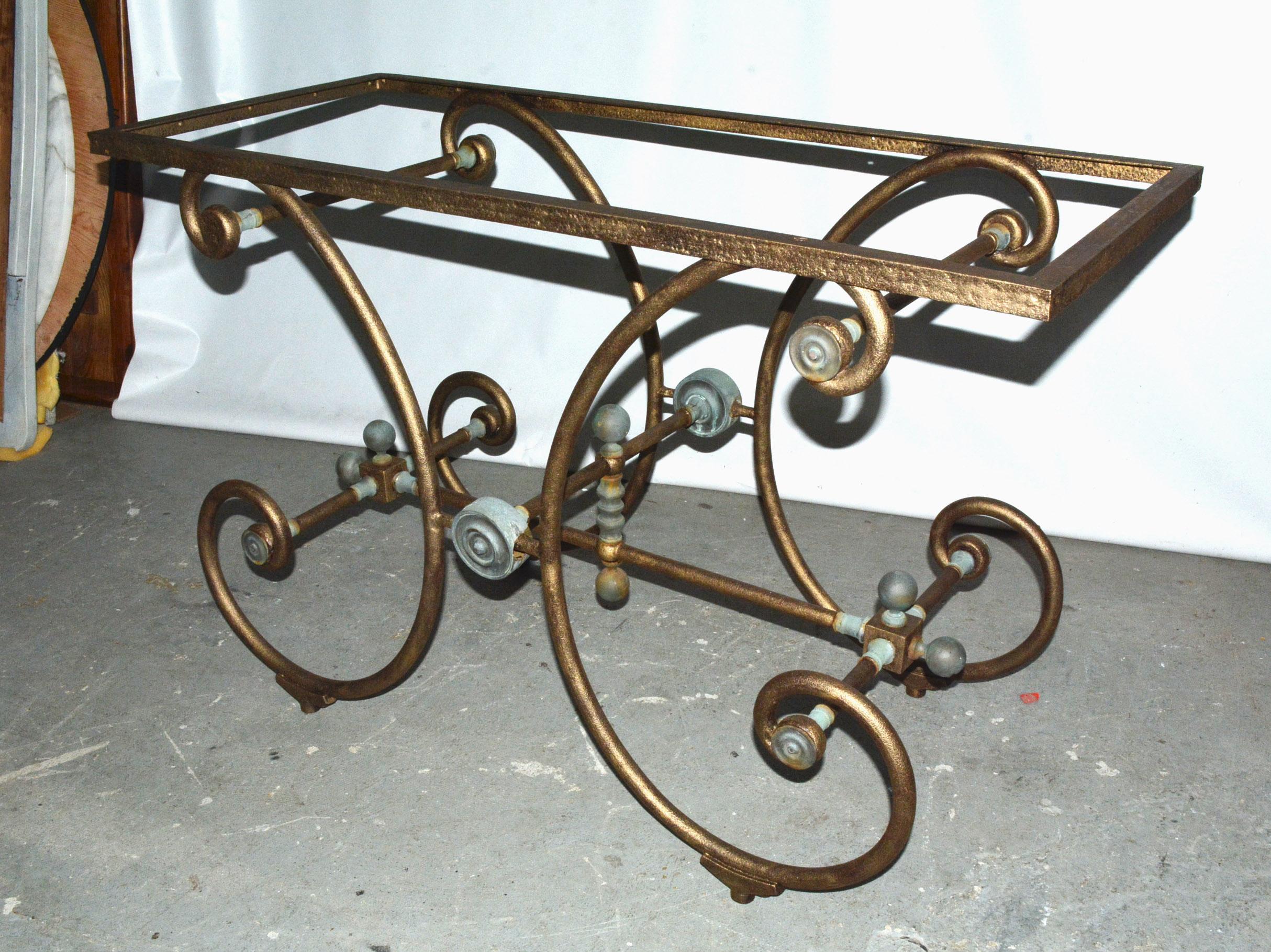 A French baker's table with touches of gold gilt on iron and wonderfully verdigris decoration is a rustic yet elegant example, with classic metal form trestle base of scrolling iron legs. The base is 19th century and was probably a pastry table in