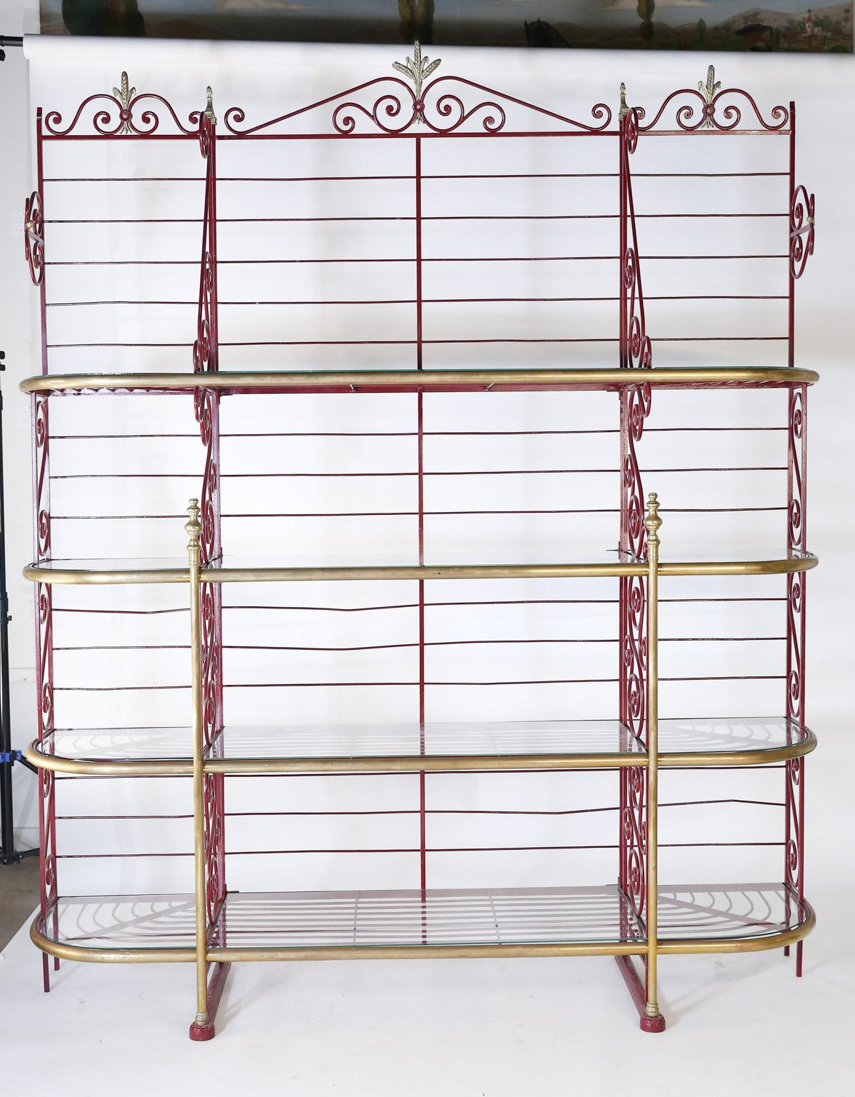 This is an early 20th century bakers rack made of iron with brass trim. The makers name, Echalie and Biabaud, Paris is embossed on the cast iron feet. The metal shelves are topped with glass providing a sturdy flat surface for displaying items of