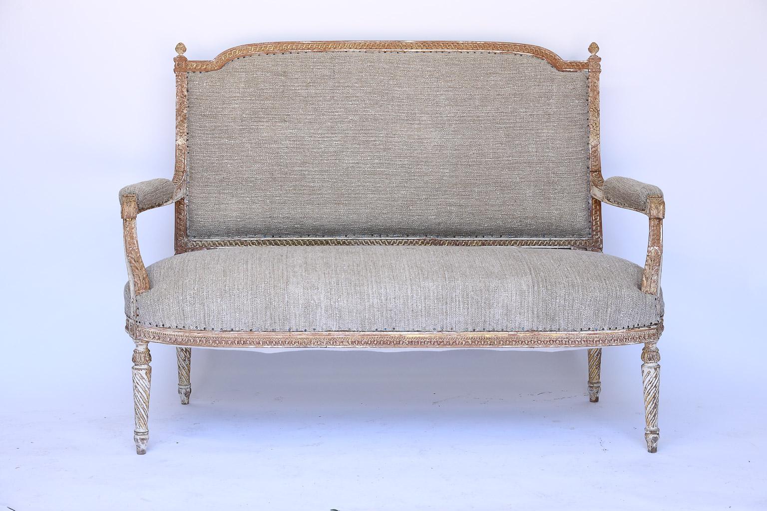 This is a beautiful antique French banquette. The banquette is strong, sturdy and upholstered in vintage French linen fabric that is enhanced by small tacks.