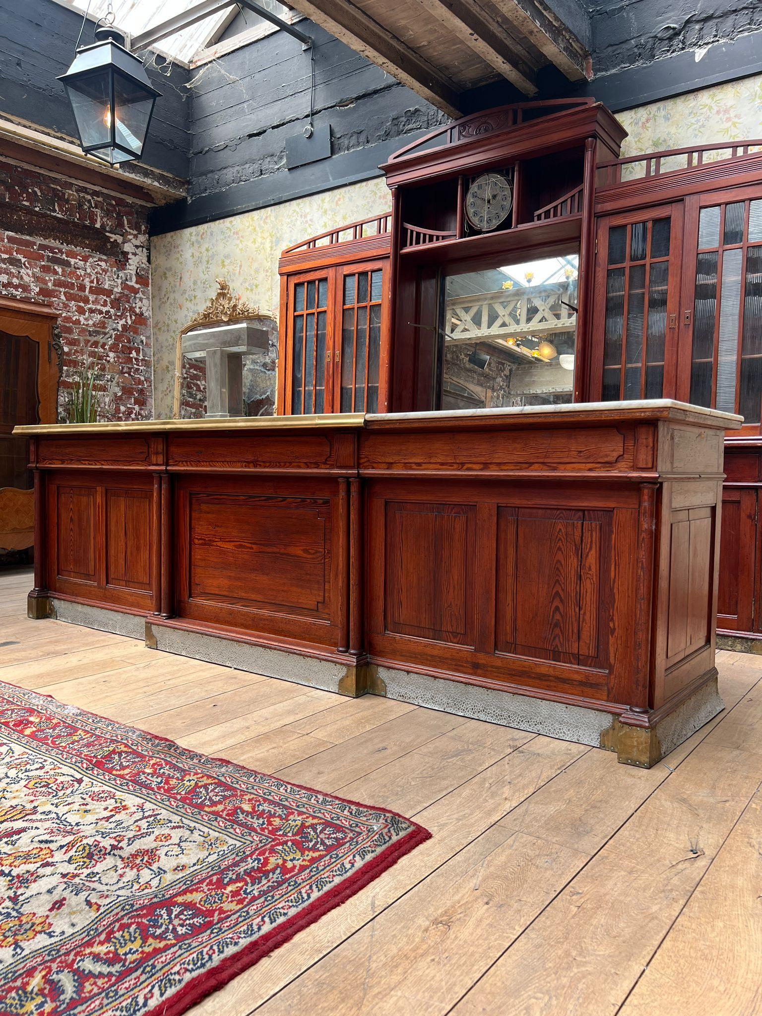 Antique French Bar Counter with Back Bar, Early 20th Century
Magnificent bar counter with matching back bar in solid wood and original patina, dating from the early 1900s. This authentic ensemble features a long zinc and brass top, drawers, paneled