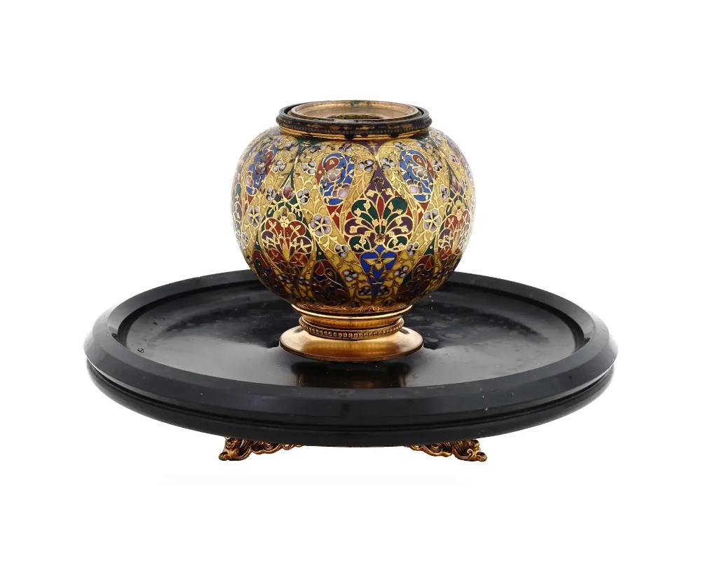 An antique French Barbedienne enamel candlestick holder. Crafted with meticulous attention to detail, this piece showcases the intricate champleve enamel technique, a hallmark of the Barbedienne workshops expertise. The vibrant enamel hues contrast