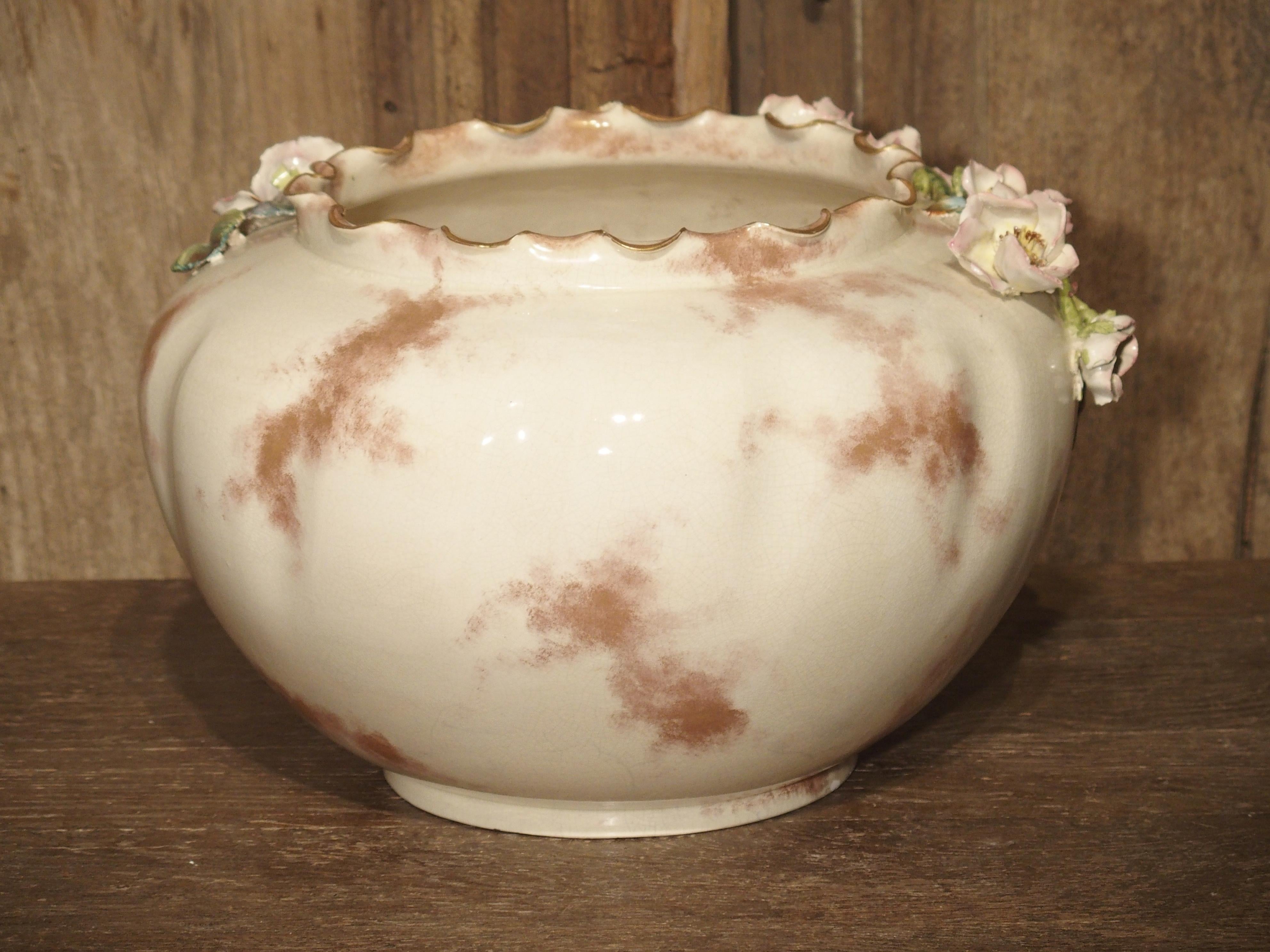 From France, this gros relief barbotine cachepot has been painted in pale pinks, greens, yellows, creams, and browns. A certain type of clay called Kaolin is used in the making of barbotine. Kaolin allowed the sculptor to form paper thin petals and