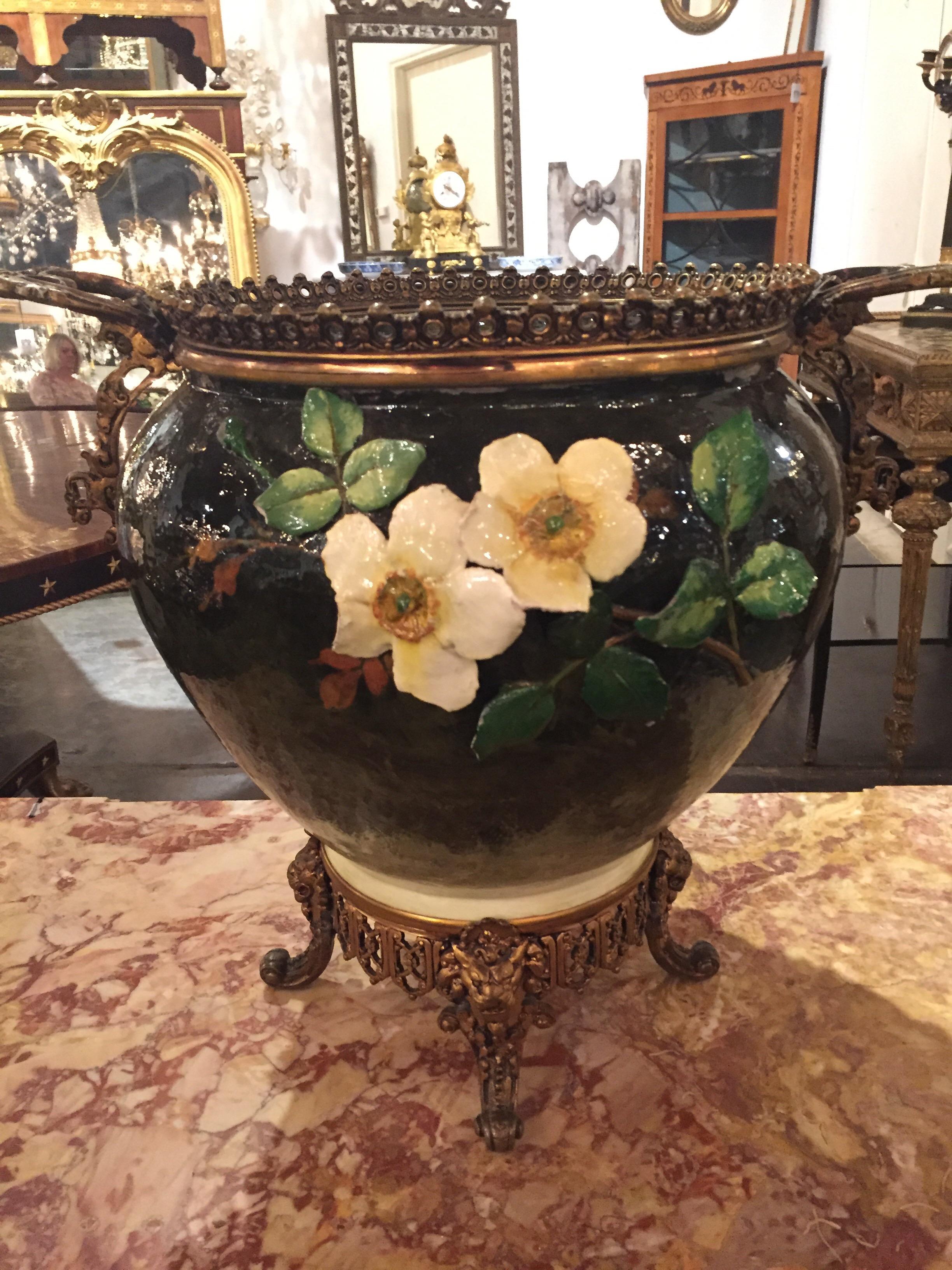 Antique French Barotine vase which is hand painted in dark blue. The vase has high relief white, pink and yellow flowers and it has a bronze pedestal and handles. It would make for an exquisite floral arrangement in a dining room or living room.