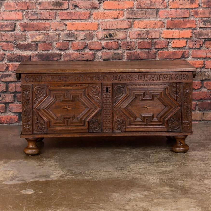 There is tremendous character and craftsmanship in this stunning hand carved oak trunk including beautiful inlay, carved floral designs, and wonderful deep moldings. Of special note is the carved inscription 'Tel Est Notre Bon Plaisior,' which
