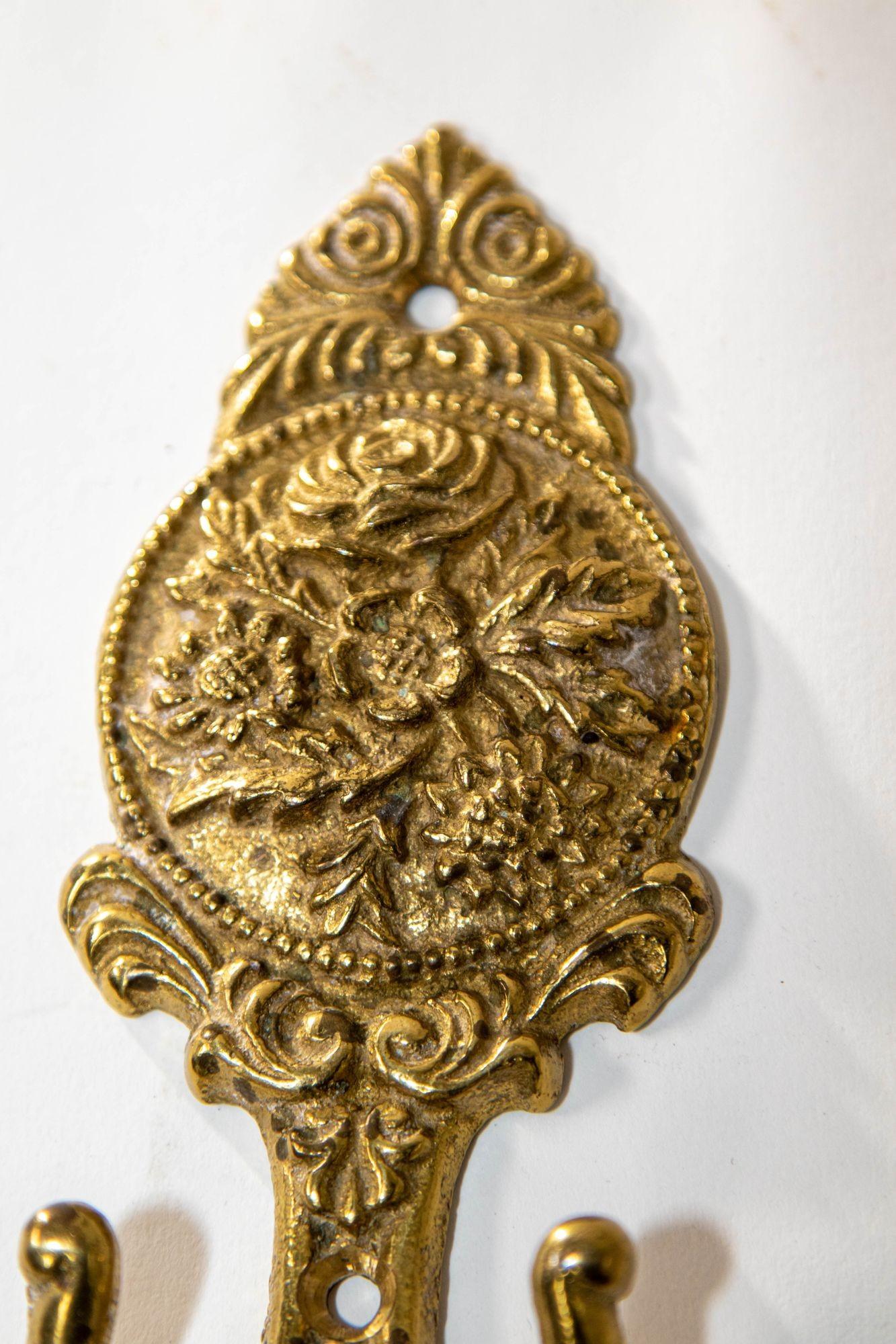 Architectural French Cast Brass Floral Wall Hook Decor.
Mid-20th century Baroque Louis XIV style wall cast brass double hook wall plate featuring an intricate floral pattern with roses and
leaves, in relief.
The hook is fastened to a shaped