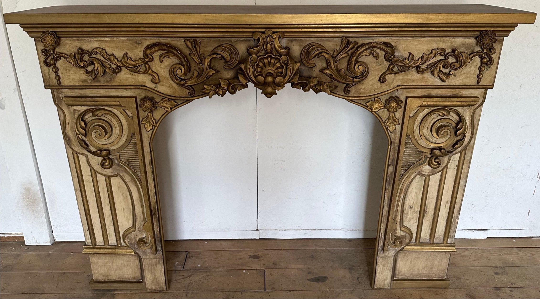 A rare decorative gilt-wood hand carved painted Baroque style 19th century French fireplace mantel -- finely carved detailed shell, foliage, scrolled swags, supported on wide plinths. The spandrels with conforming, flowing swags, All beneath a gold