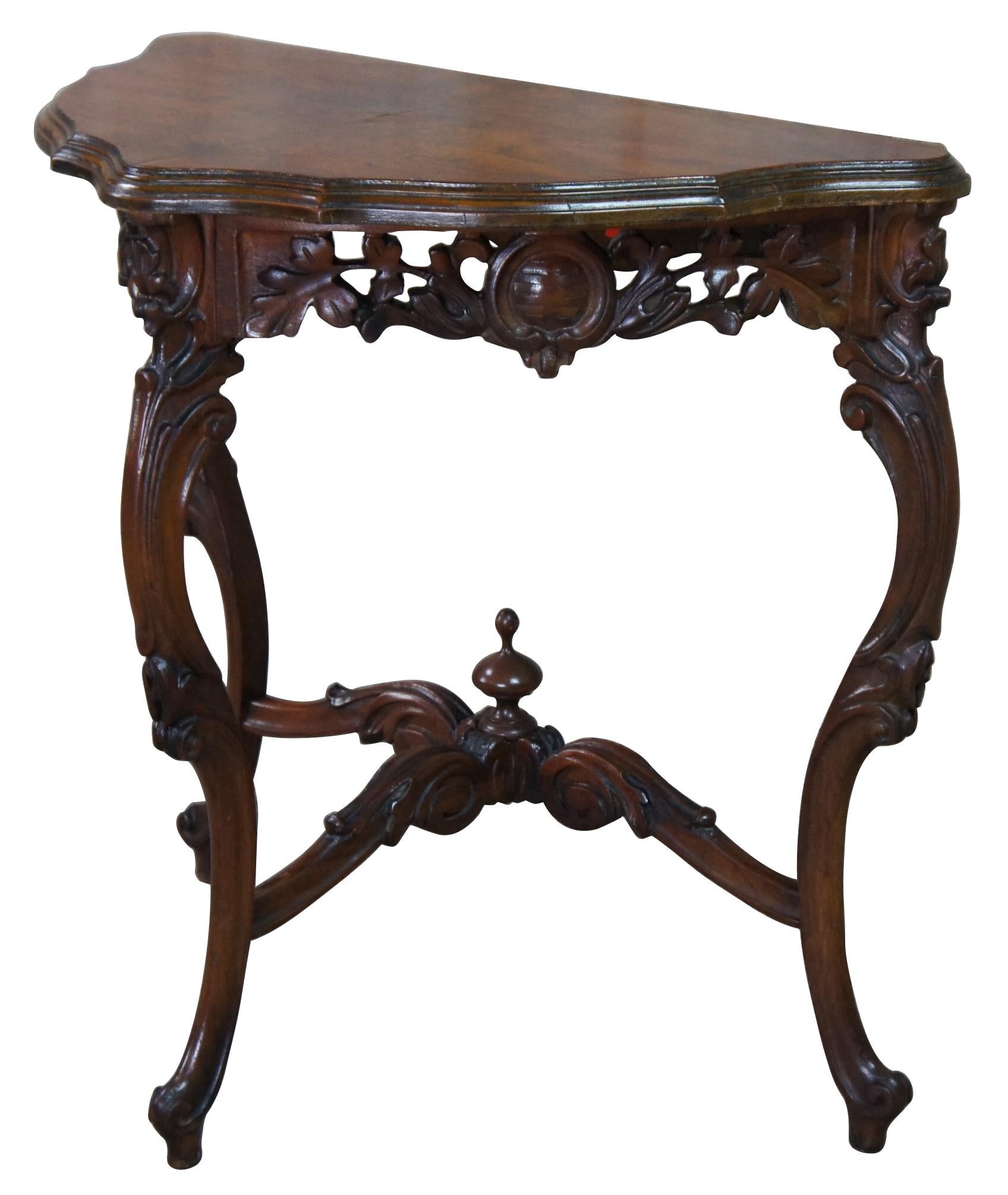 Antique French Baroque or Rococo side console table. Made of burled Walnut featuring triangular form with a pierced apron centered by baroque shields and foliate carvings. The table is supported by three reverse scrolled legs connected by an ornate