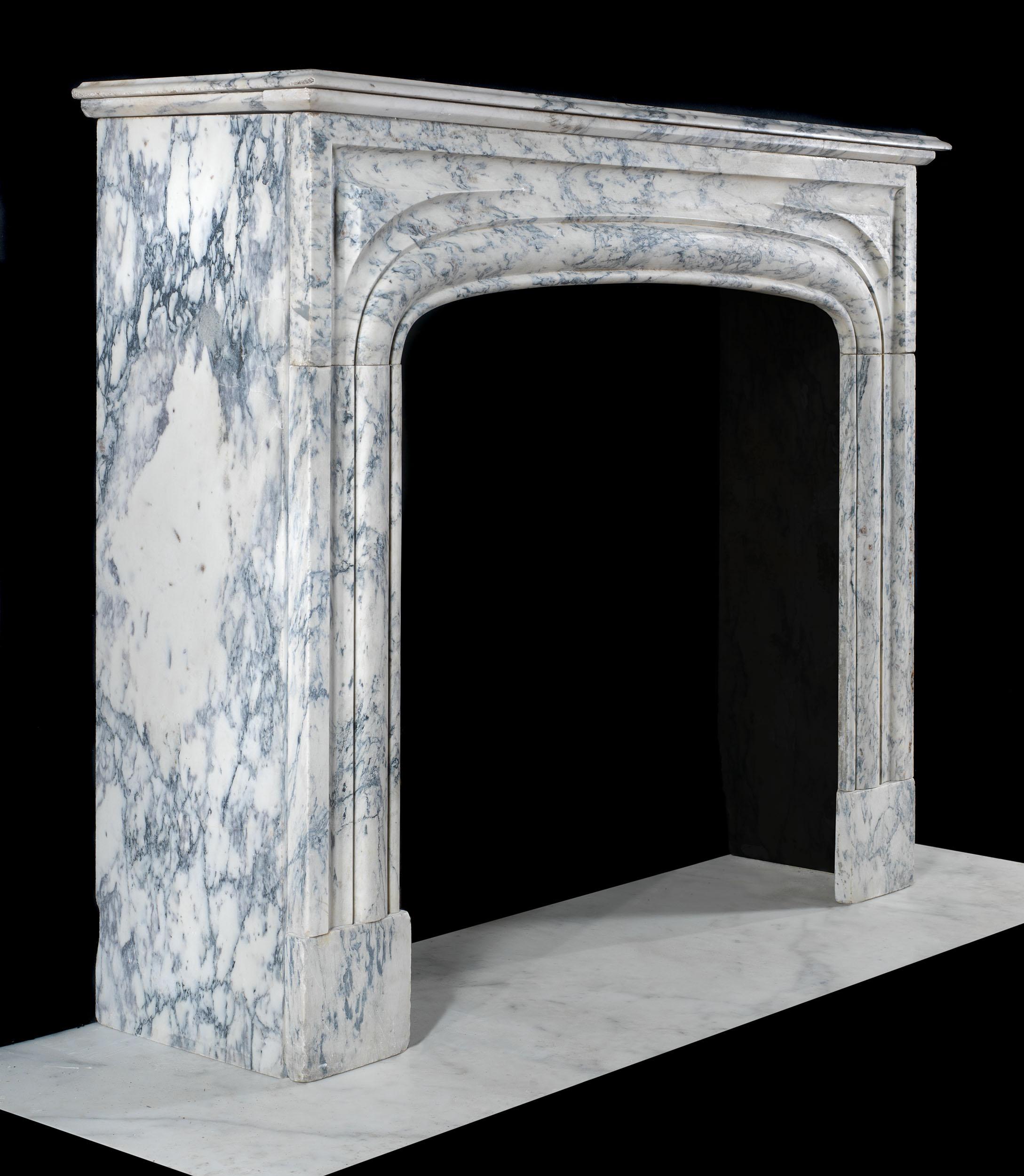 A delicately veined blue/grey and white Breccia Marble antique chimneypiece in the French Empire style with a slow arched opening and deep side returns. French, circa 1860.
   