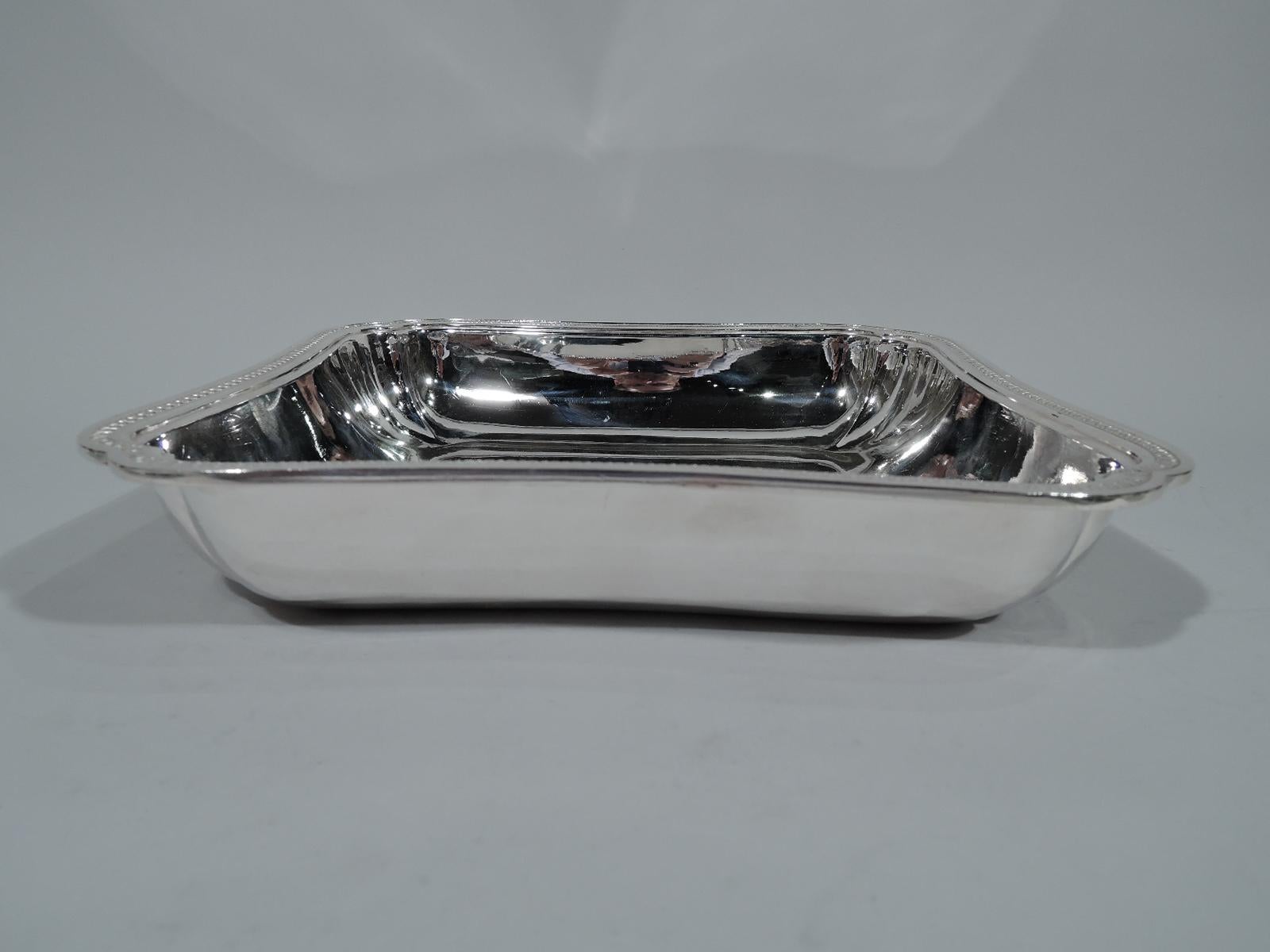 French 950 silver serving bowl, circa 1900. Square with concave sides and lobed corners. Overhanging rim has classical leaf-and-dart border and double-scroll corners. Stylish and restrained. Fully marked with Minerva head and indistinct maker’s