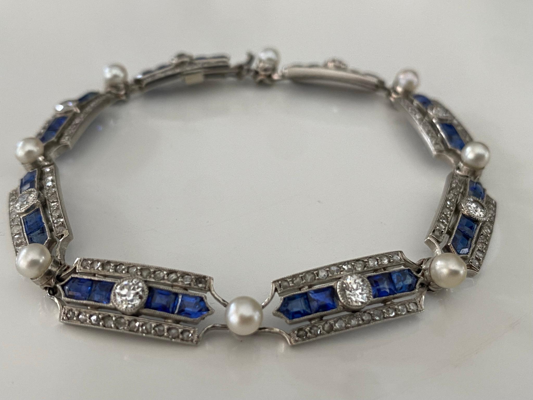 Circa 1910-1915, this magnificent antique French Belle Epoque link bracelet is composed of a repeating geometrical design centered by an Old European cut diamond flanked by four calibrated blue sapphires and two rows of small glittering rose cut