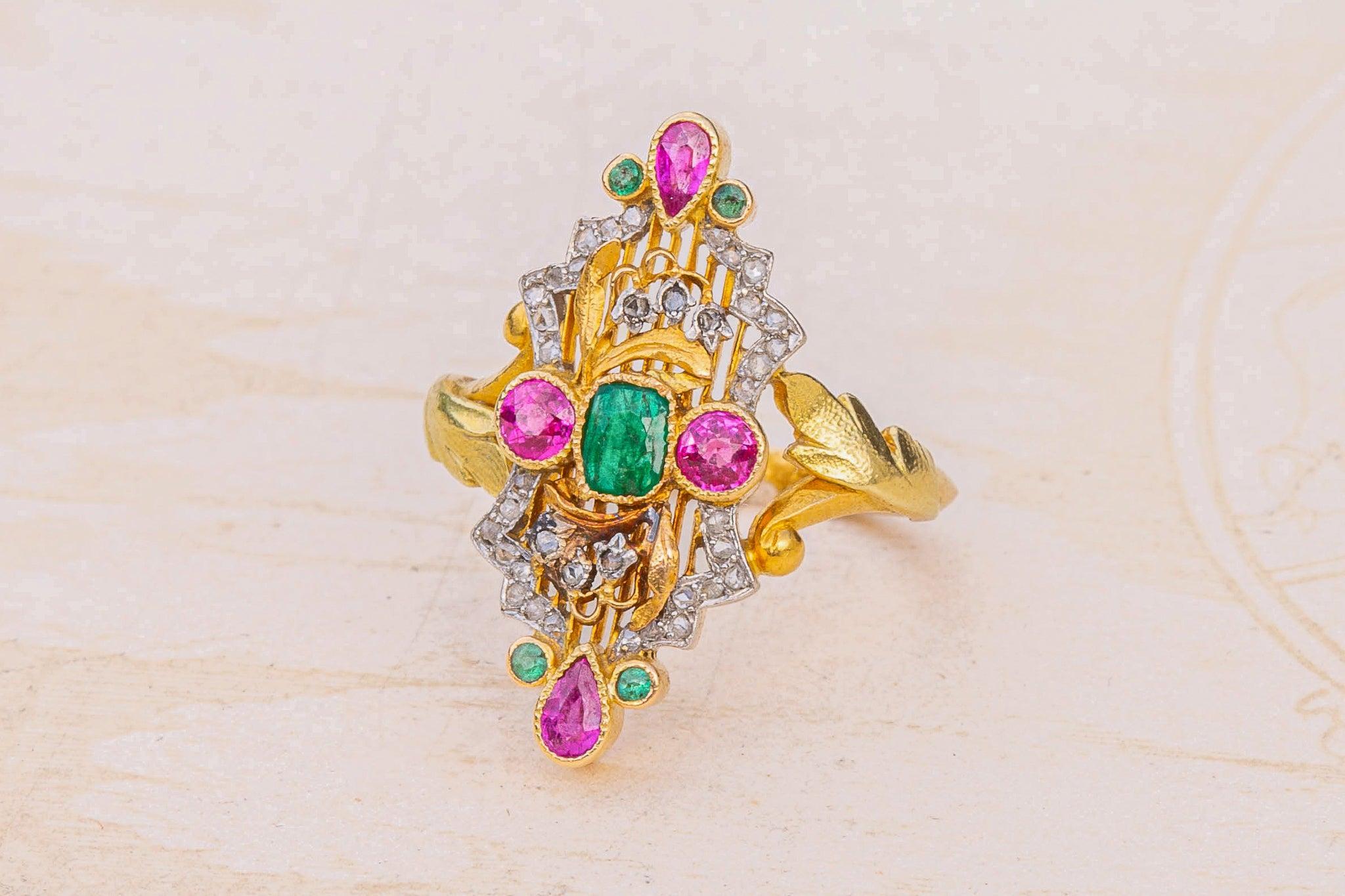Magnífico anillo de oro de la Belle Époque, fabricado en París, hacia 1910.

Este anillo en racimo presenta una magnífica disposición de esmeraldas y rubíes engastados con milgrain, decorados con motivos florales y diamantes talla rosa en engastes