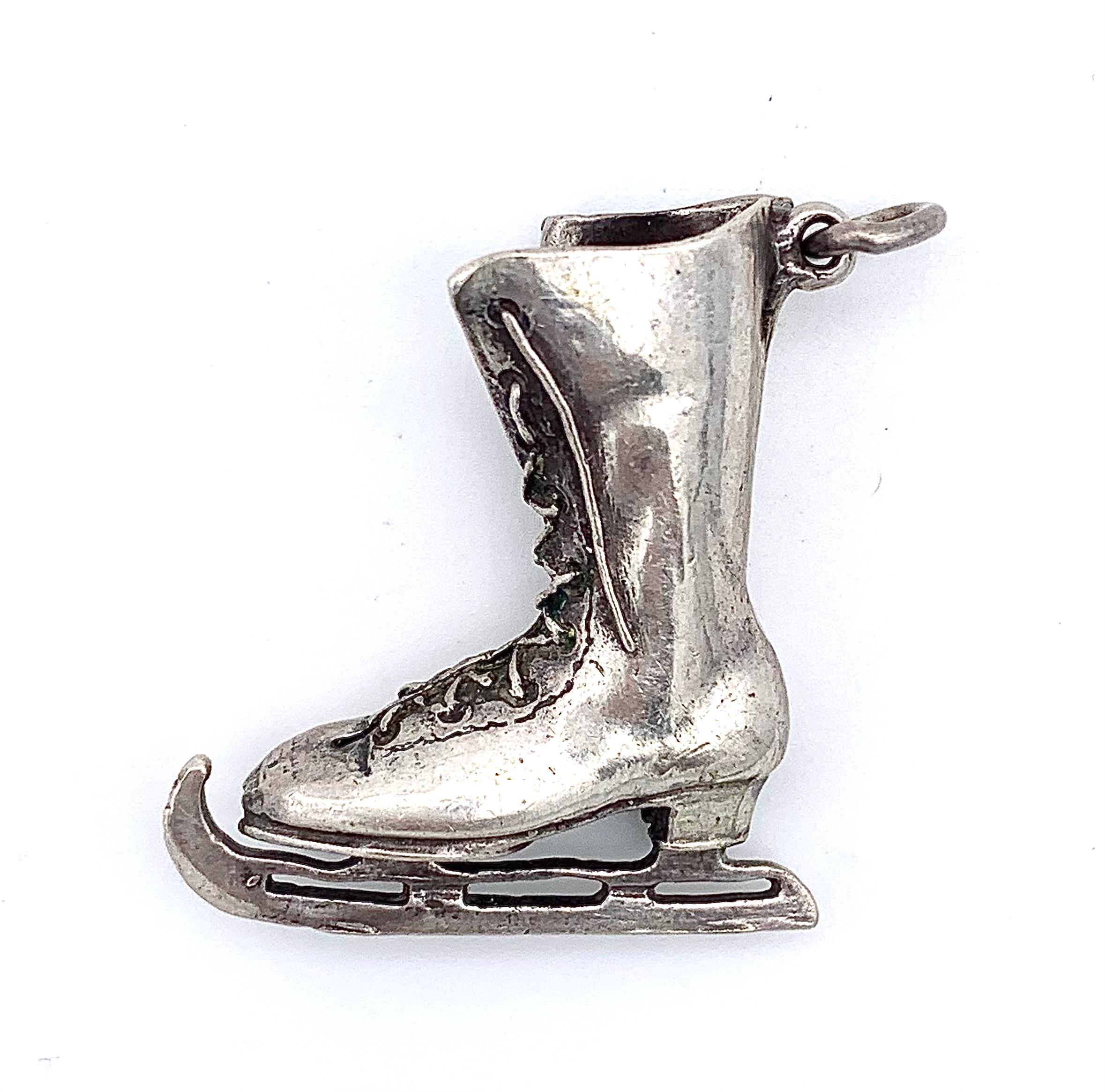 Ce joli pendentif d'une botte à lacets de patinage sur glace a été réalisé
vers la fin du dix-neuvième siècle, époque à laquelle le patinage sur glace était un loisir à la mode. La botte joliment modelée a été coulée en argent et finie à la main.