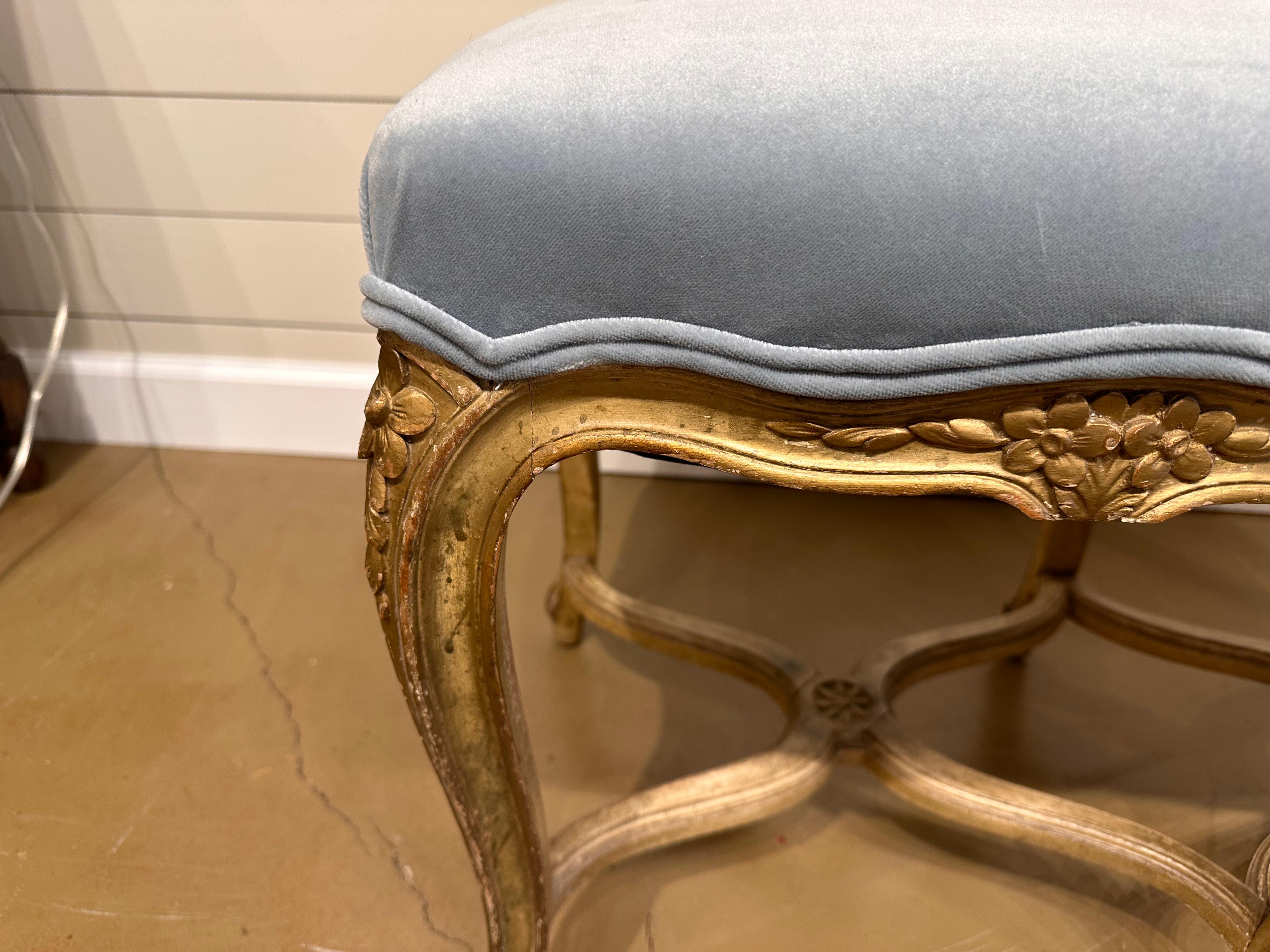 This is an early 19th century French bench we just had recovered in a beautiful sky blue, crushed velvet fabric. Notice the double cording around the edges, fitting to all the contours of the bench making for great detail. The  frame show perfect