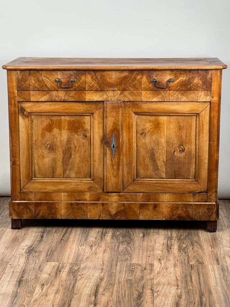 Este elegante bufé francés de mediados del siglo XIX encarna la refinada sencillez del periodo Biedermeier, que cobra vida en madera de frutal ricamente matizada. Probablemente fabricada en la Francia provincial, su forma es clásica y sobria, pero