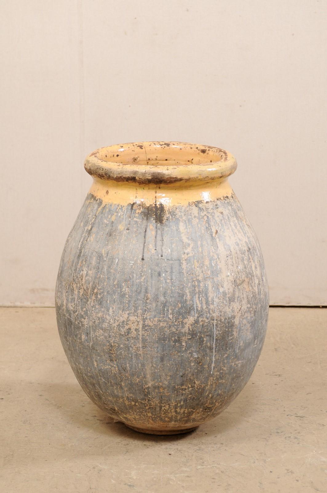 A French Biot jar from the early 20th century. This antique vessel from France features a mellon glazed and rolled rim & neck, with a wonderfully bulbous-shaped body. Biot is a small village in the south of France, famous for their clay pottery, and