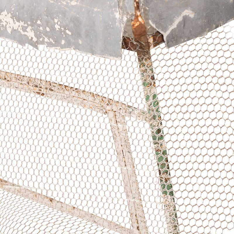 A vintage metal birdcage from France. Featuring a wire mesh enclosure, a pointed metal roof, and chipping green/blue paint. This piece has the perfect patina and is a beautiful addition to any home for a unique decor touch. 