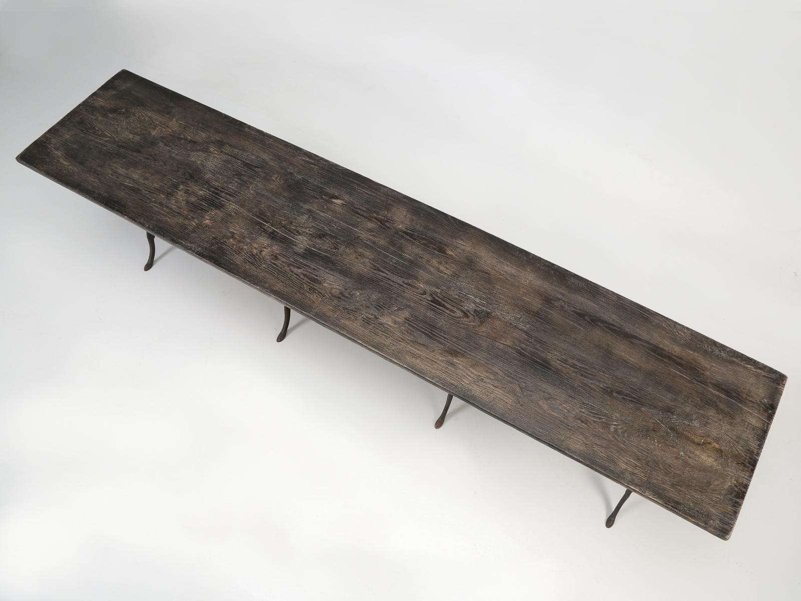 Antique French Bistro table composed of a distressed patina wood plank top and a cast iron trestle base. Being 113” long, the antique French trestle table will seat 12 people. This is by bar the longest antique French Bistro table we have ever