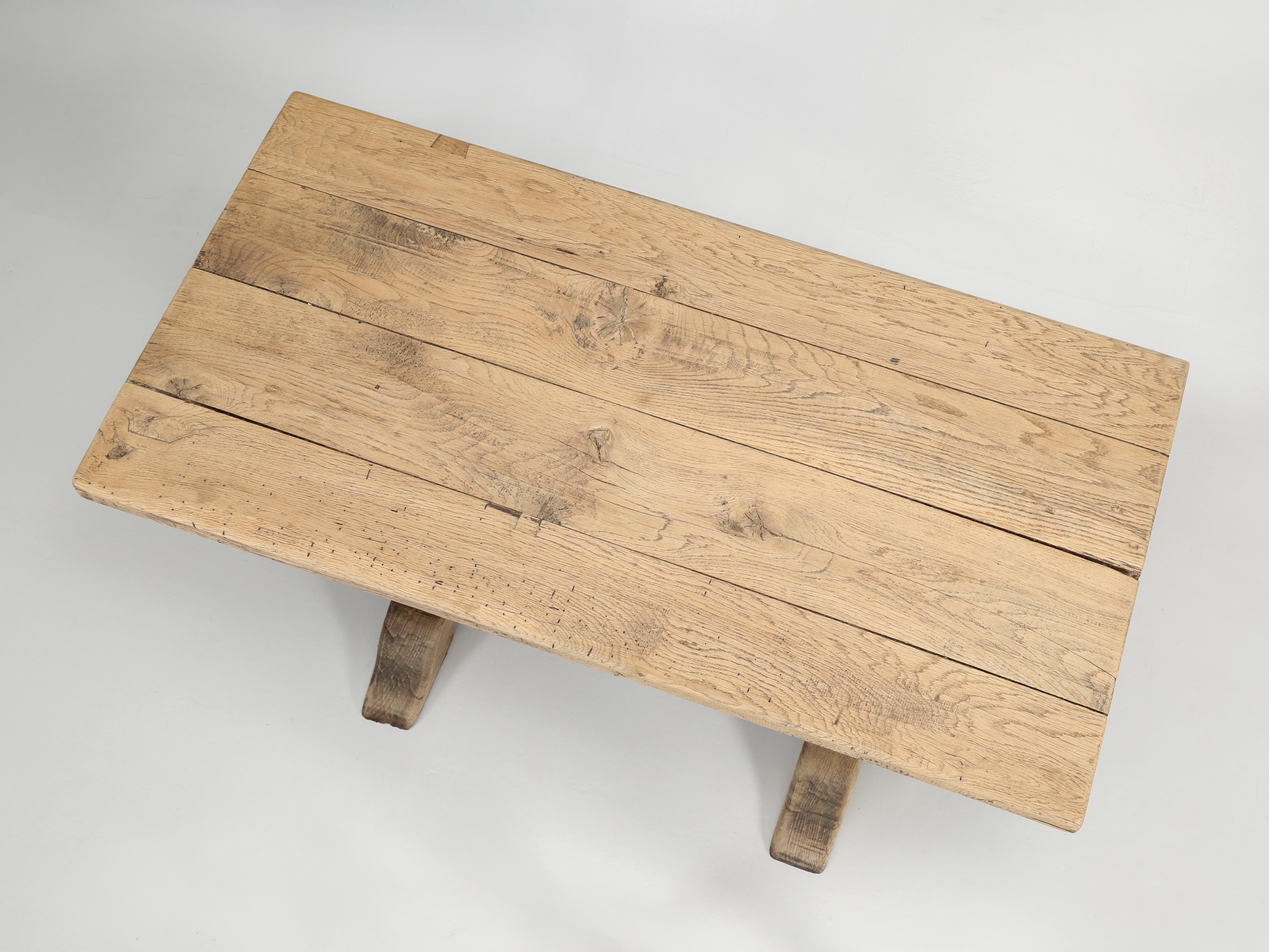 Antique French bistro table made from washed natural white oak in a classic trestle design. We have about six of these antique French petite trestle bistro tables left in stock. All of the bistro table will show wear for they have been used in a